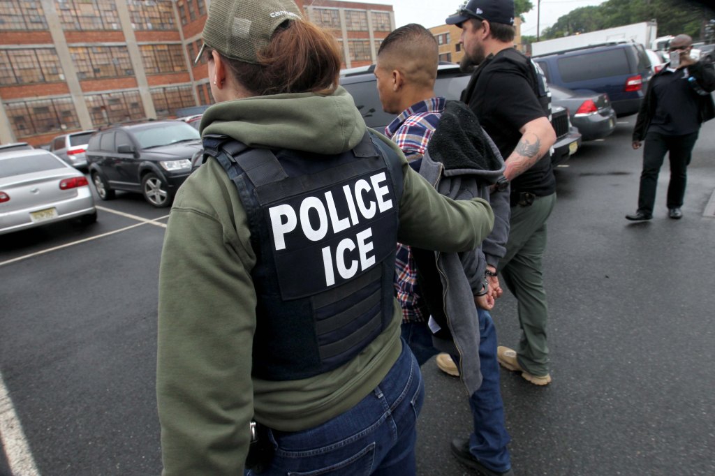 ICE agents arresting a man in handcuffs.