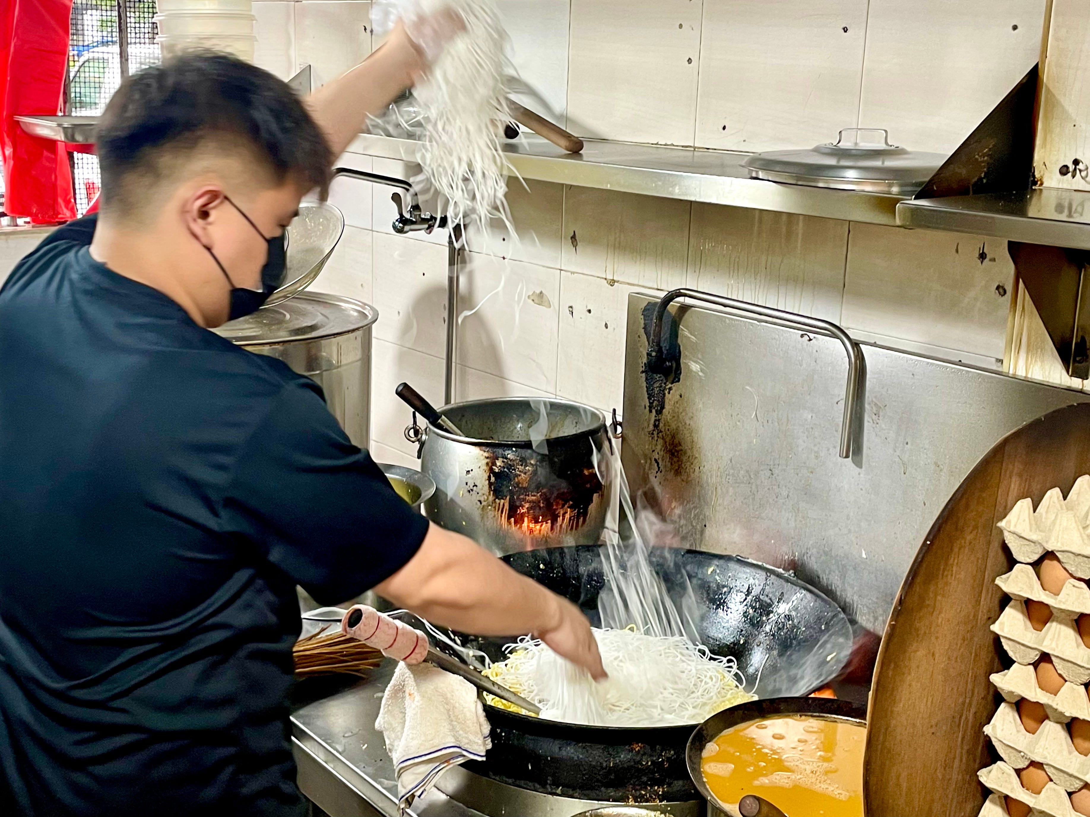 Soh Ren Jie, co-owner of Ah Jie Hokkien Mee, cooking up a batch of 10 plates of prawn noodles.
