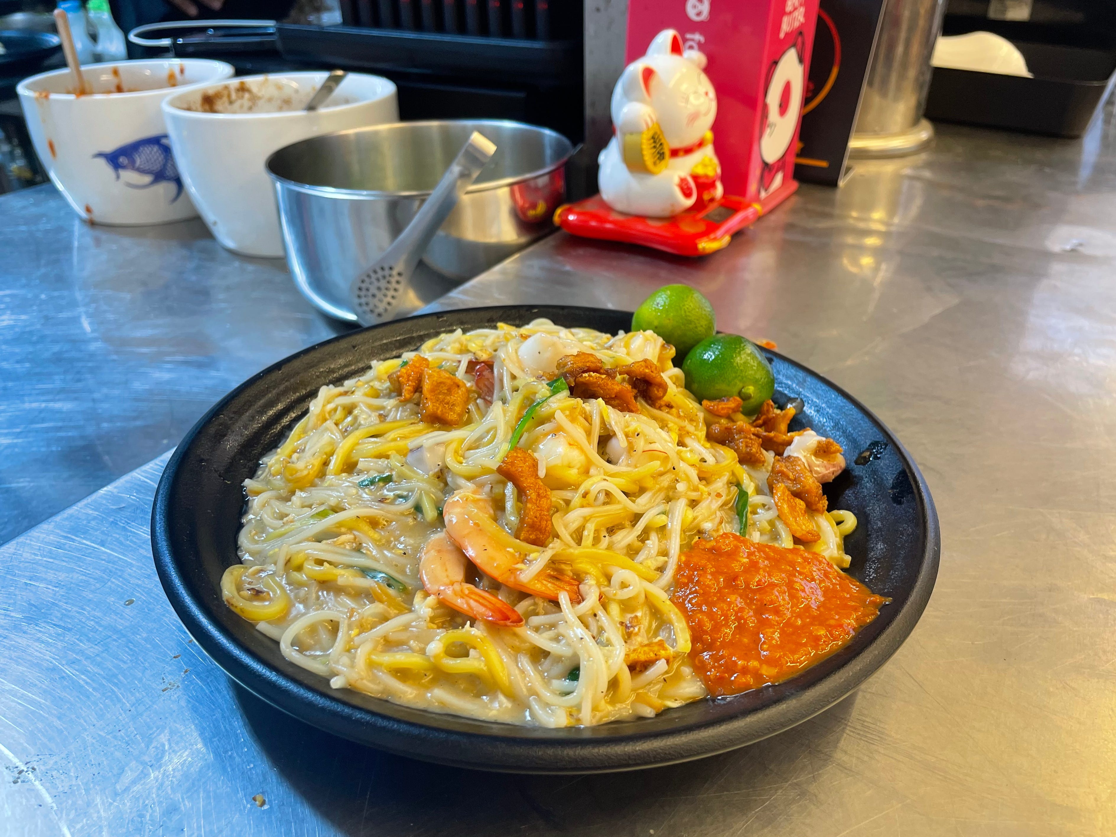 The plate of Hokkien Mee was rich and savory, topped with a sweet and spicy chilli paste, limes, and fried lard pieces.