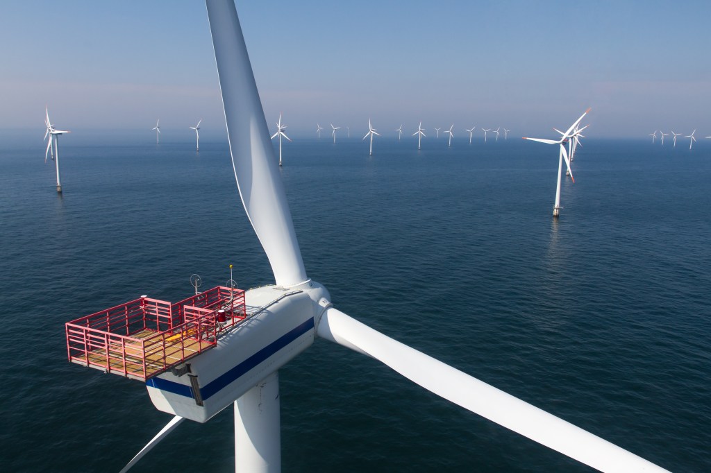 Close-up of an offshore wind turbine with a hoist basket.