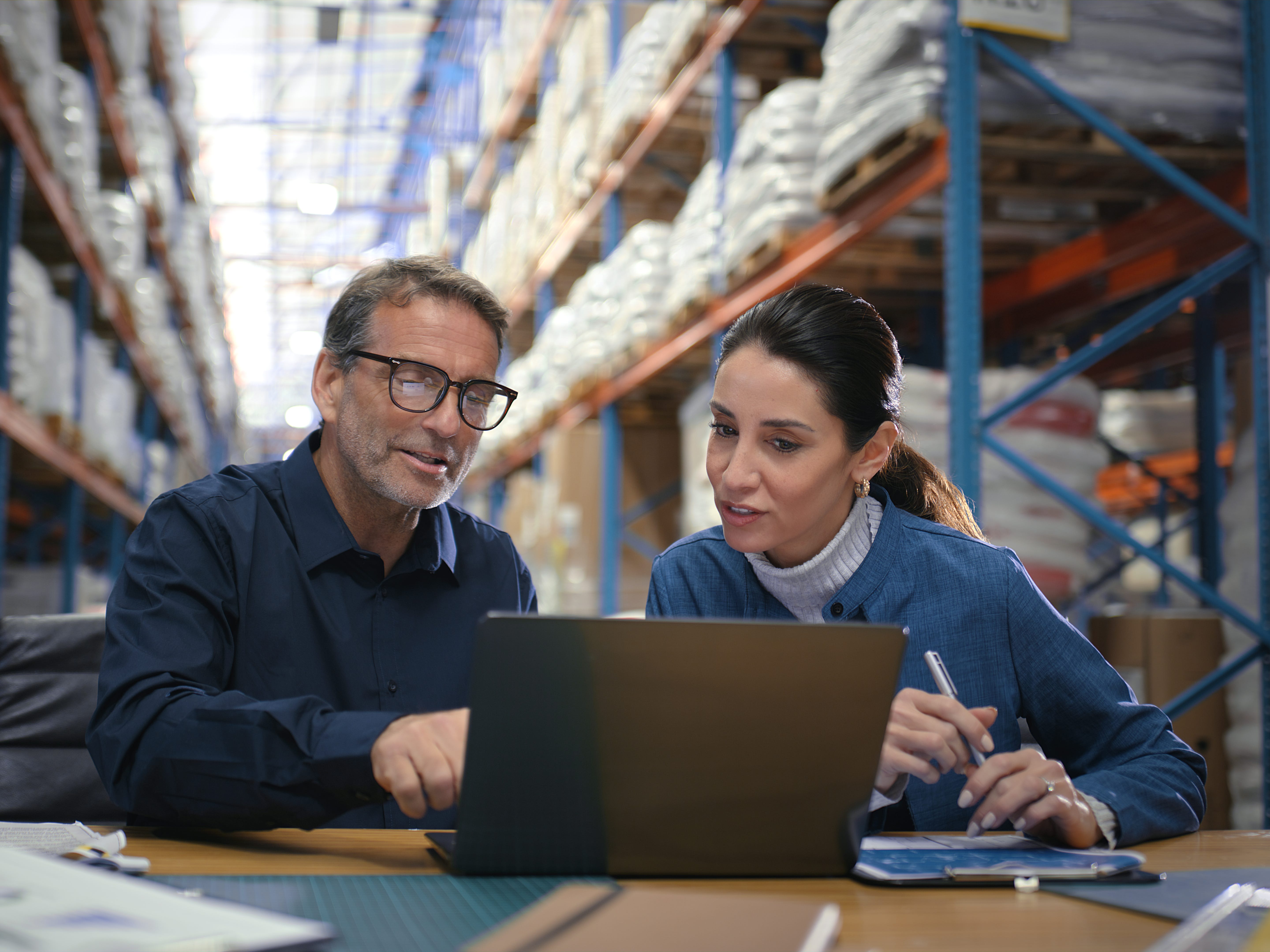 Workers looking at a laptop in a warehouse
