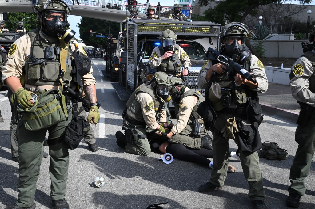 LA County Sheriff's deputies arrest a protester after unlawful assembly was declared following a 