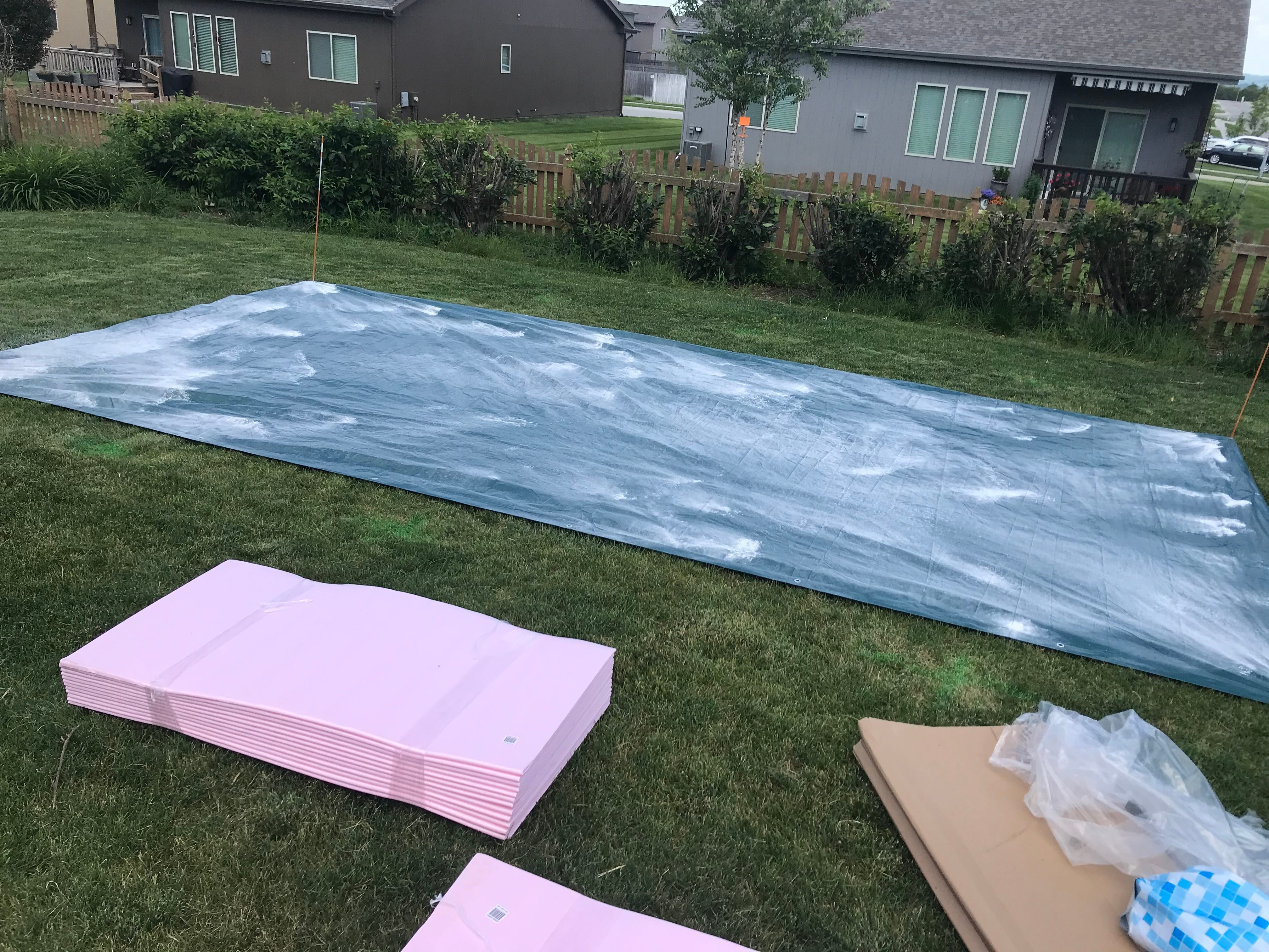 Supplies used to set up an above-ground pool are shown, including a tarp and foam insulation.