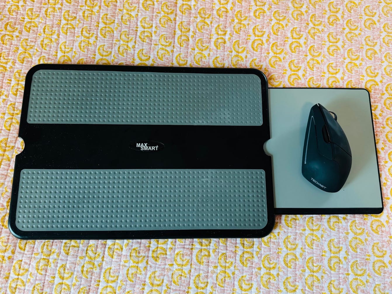 A turquoise lap desk with a mouse on a retractable mouse pad tray.
