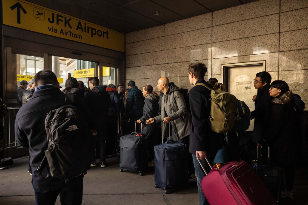 Passengers waiting at a JFK AirTrain station.