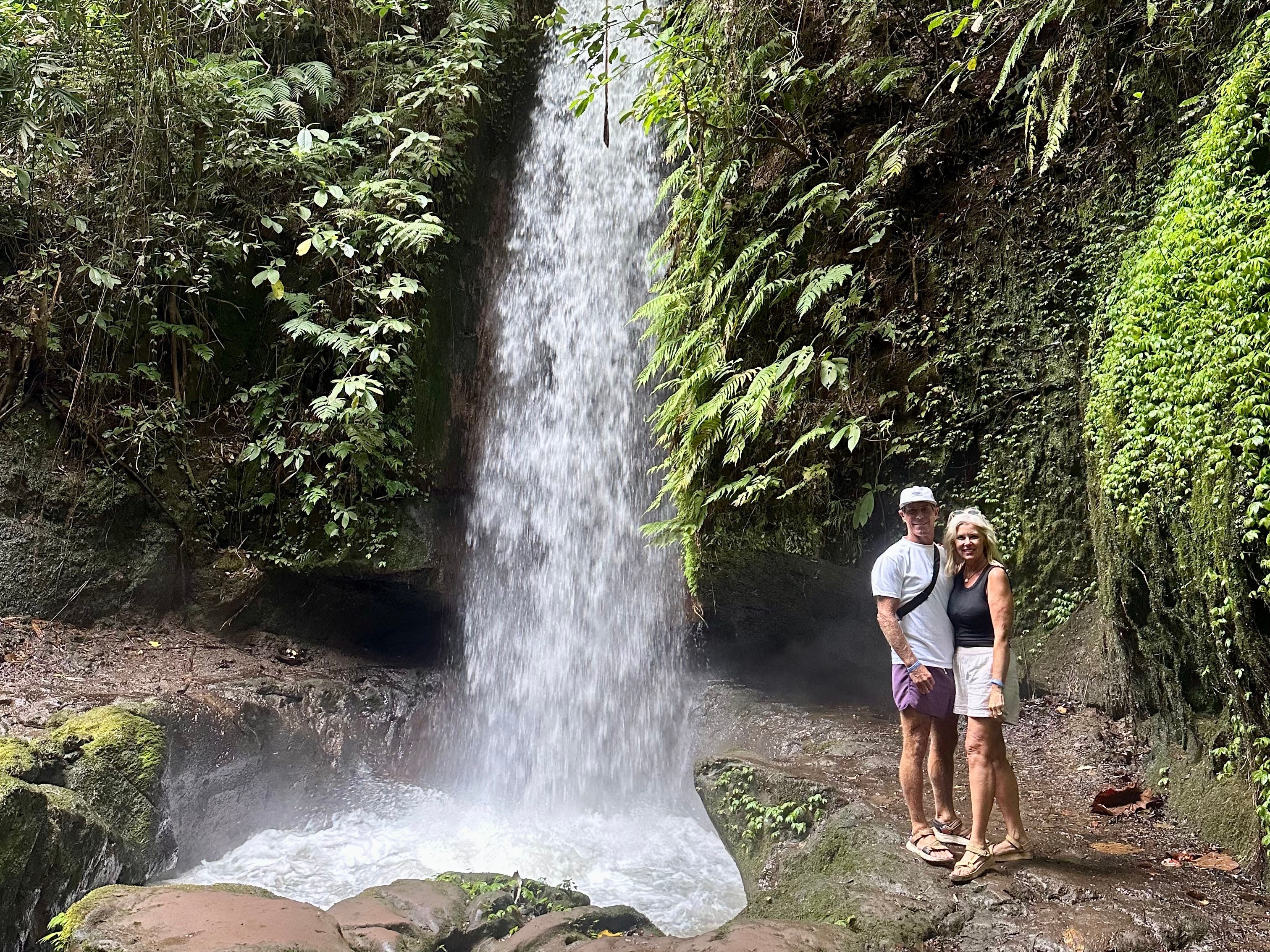 The author and her husband standing in front of a waterfall.