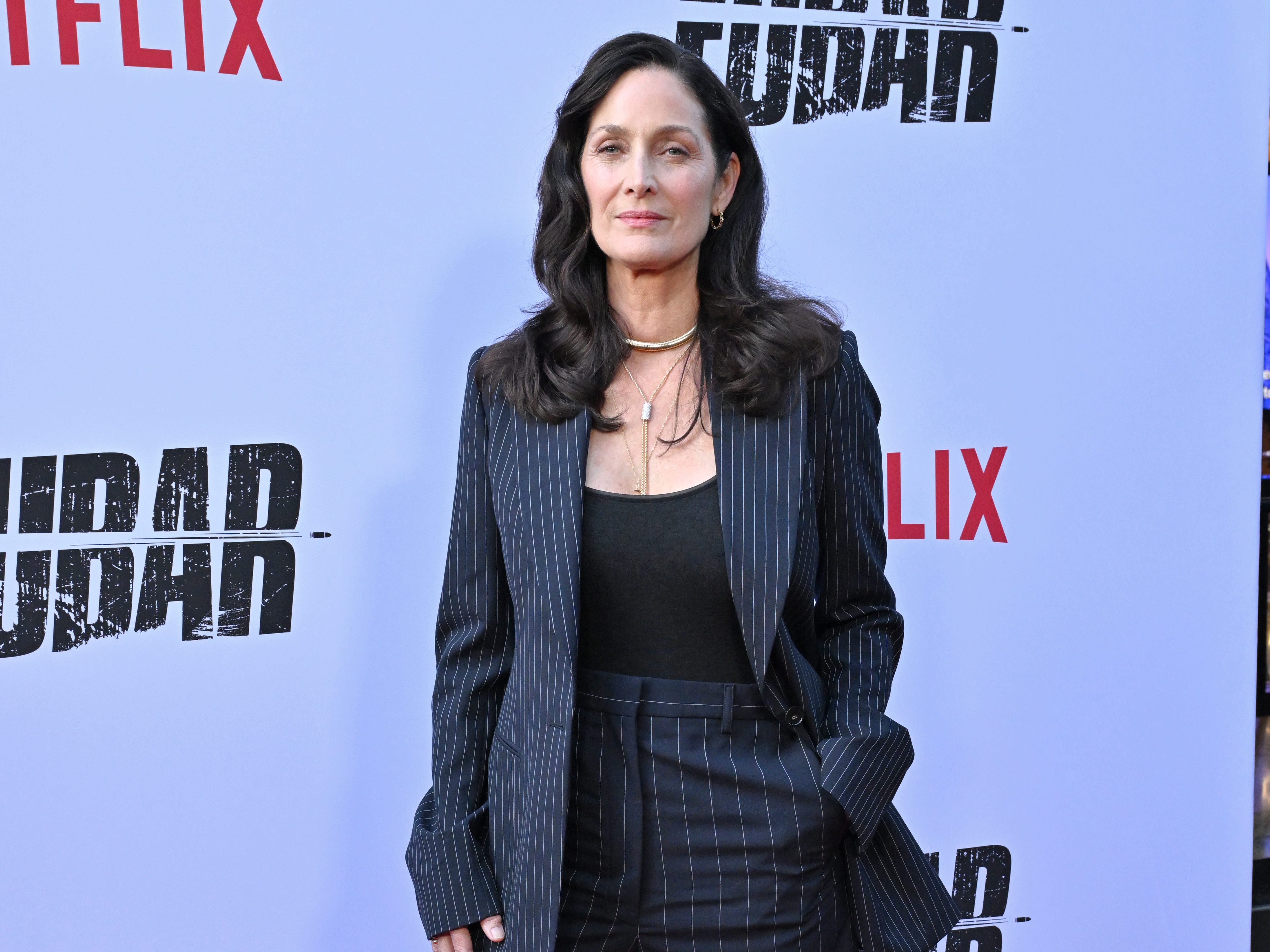Carrie-Anne Moss in a pinstriped jacket