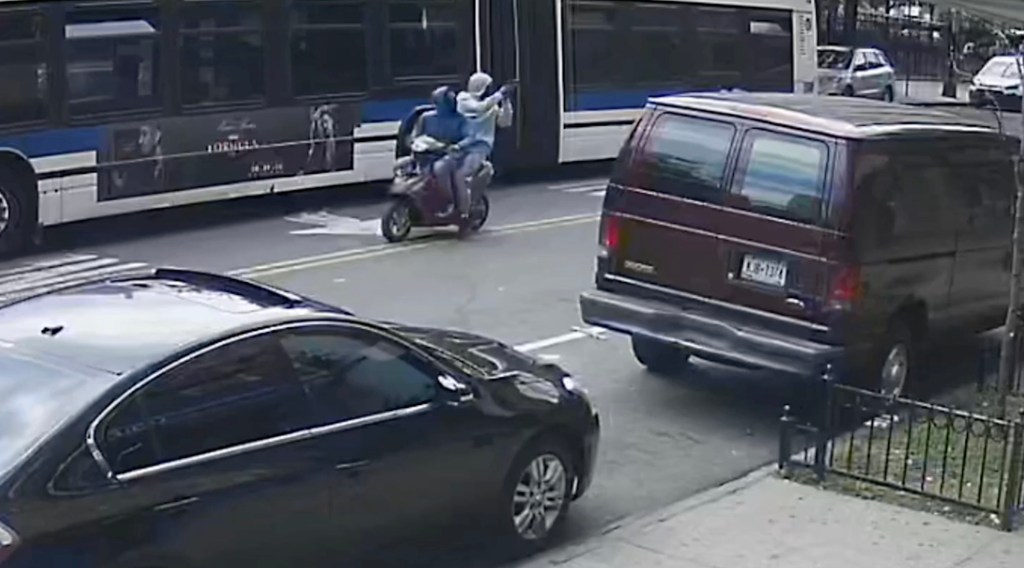 Surveillance image of two teens on a motor scooter, one holding a gun.