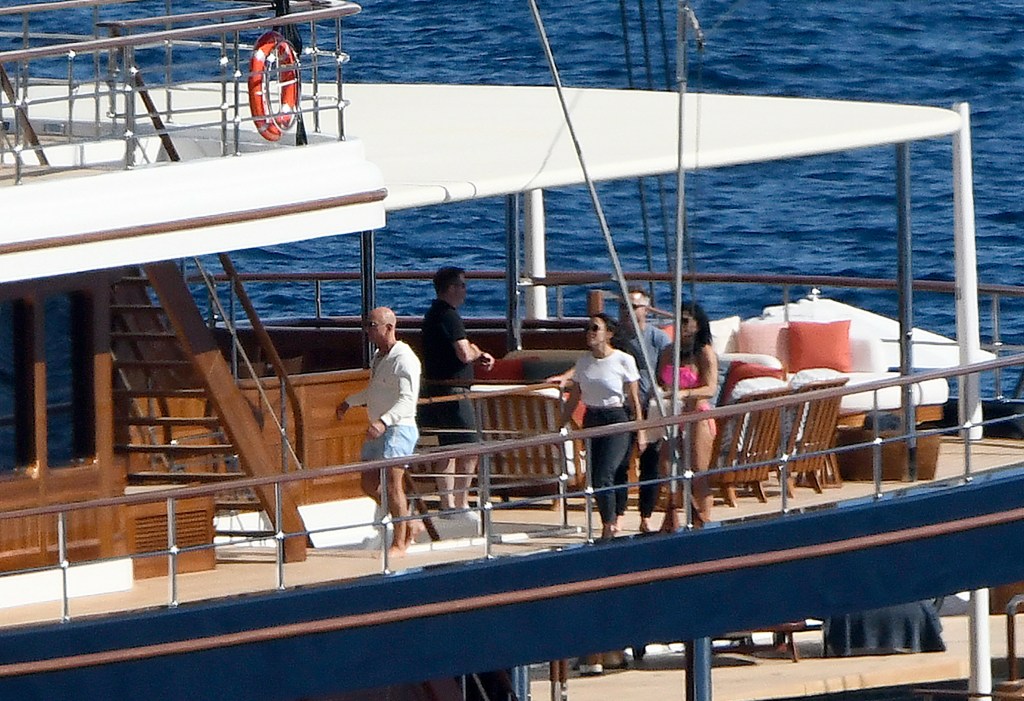 Lauren Sánchez in a grey t-shirt and black pants and Jeff Bezos in a grey hoody and blue shorts, on board the Koru.