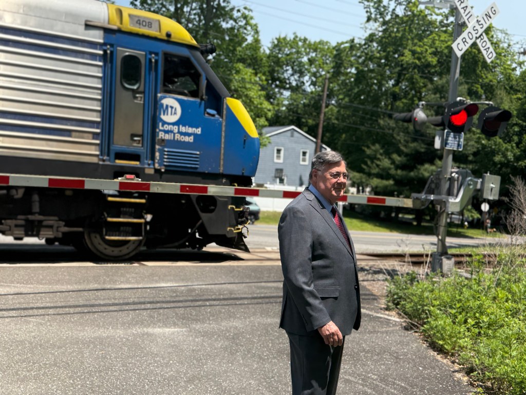 Suffolk County Executive Ed Romaine standing near a Long Island Rail Road train.