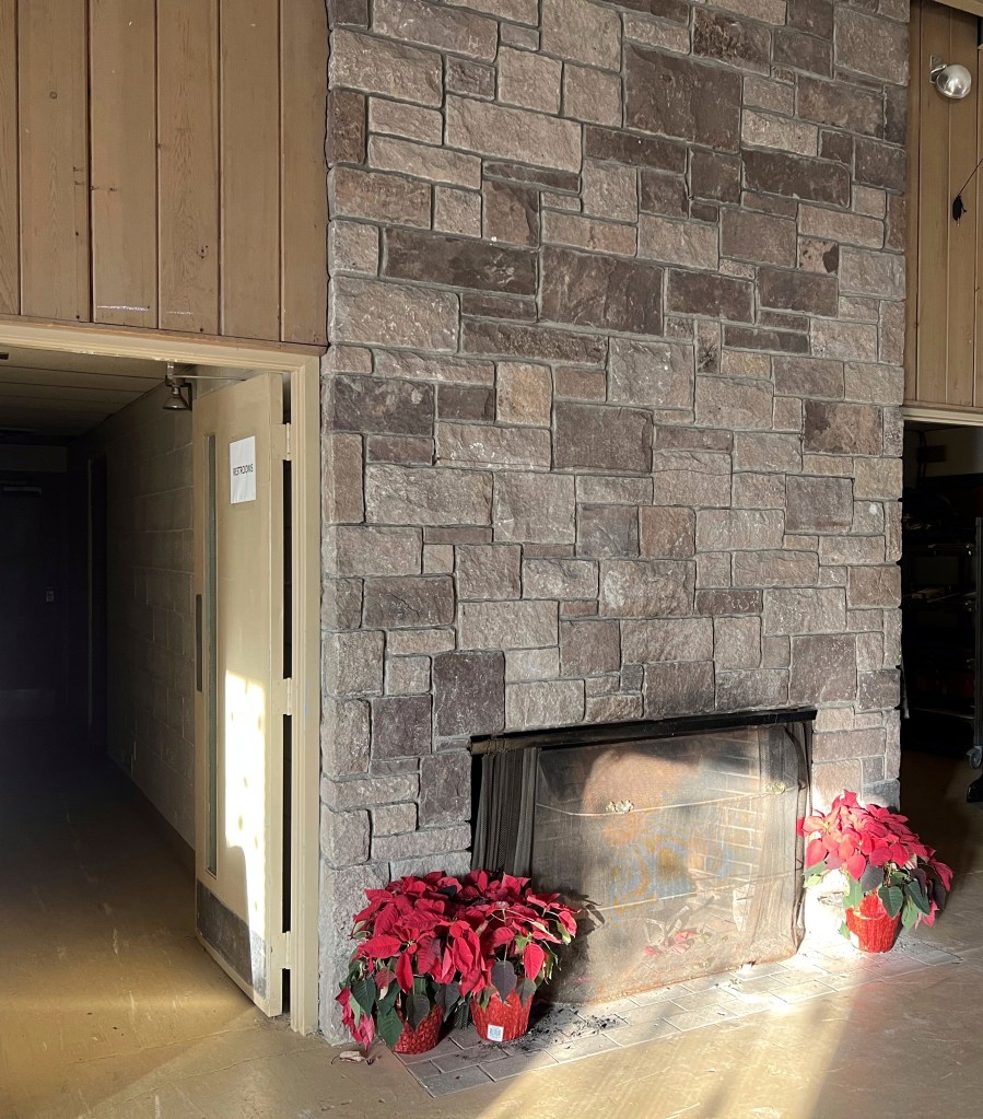 Stone fireplace with poinsettias.