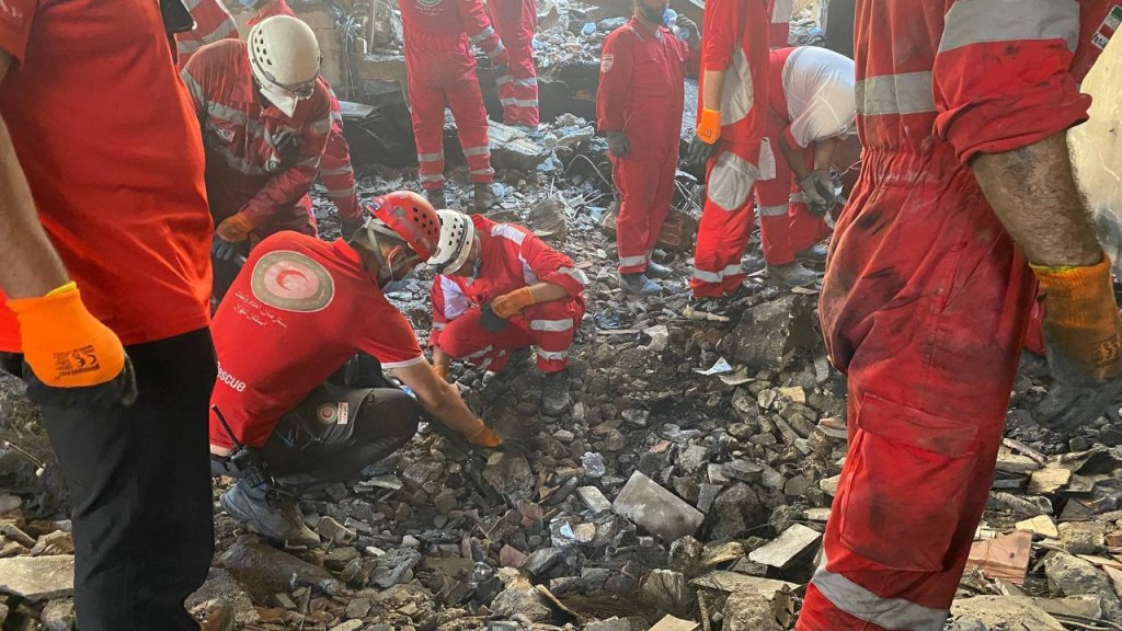 Rescue workers searching through rubble.