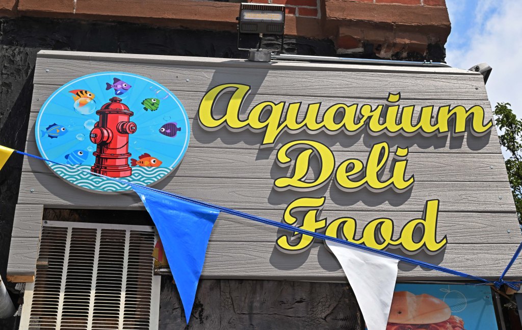 Aquarium Deli Food sign with illustration of fire hydrant and fish.