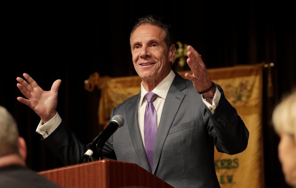 Andrew Cuomo speaking at a podium.