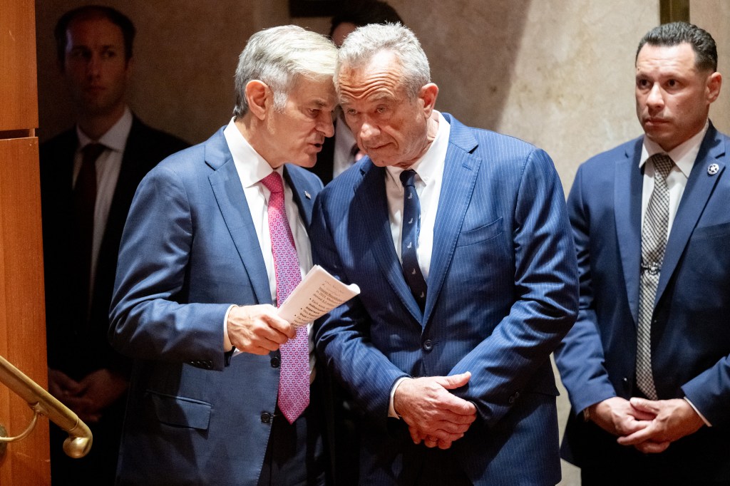 Two men in suits reviewing documents.