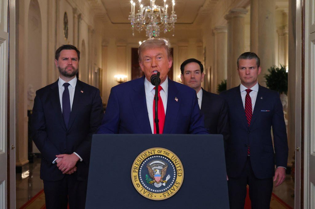 President Trump speaking at a podium in the White House with three other men.
