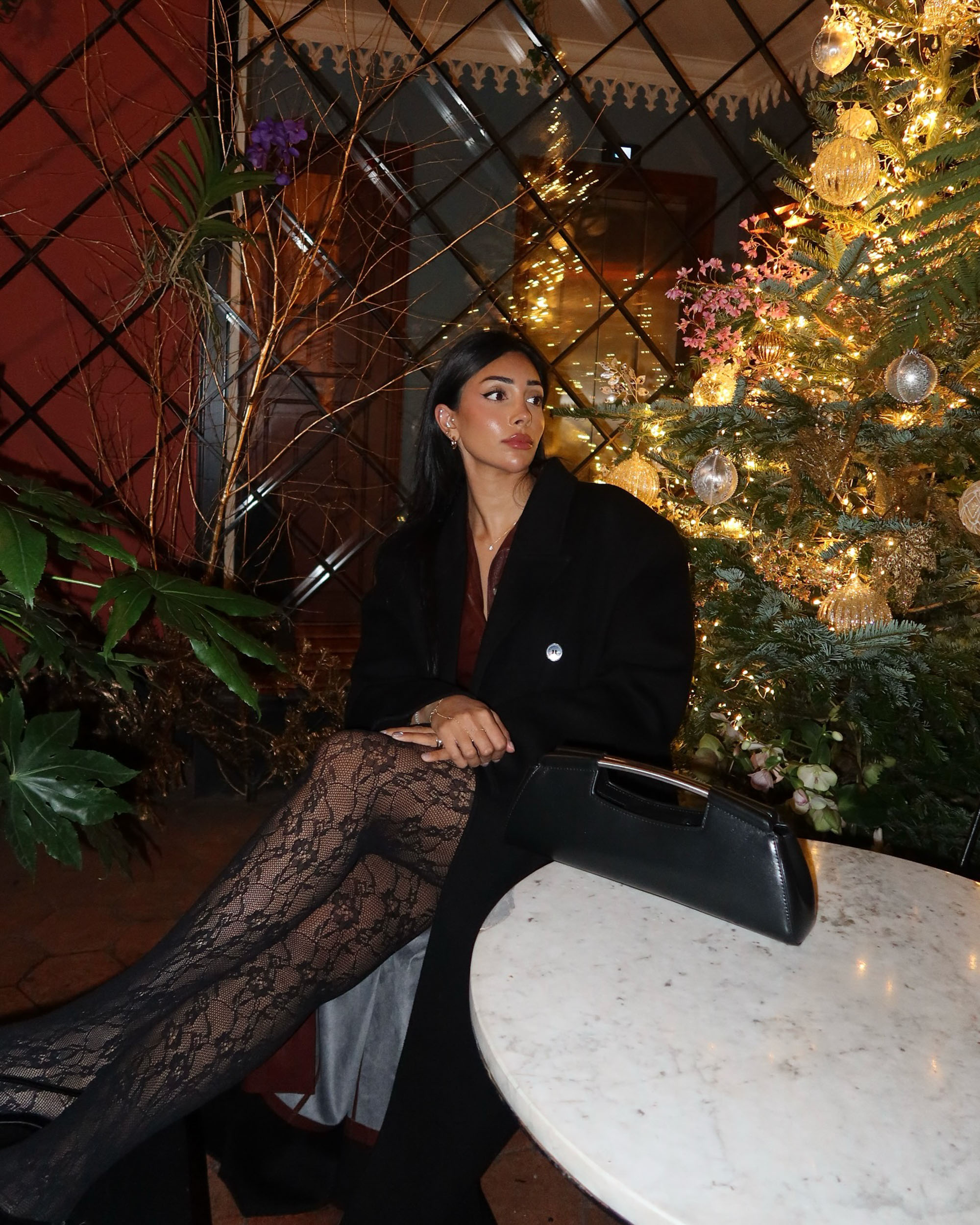 Iram Shelton in lace tights at a table. 