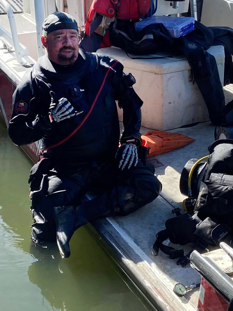 Diver giving thumbs up after recovering a lost ring.