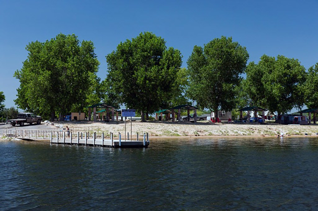 Lakeside park with several picnic shelters and a small dock.