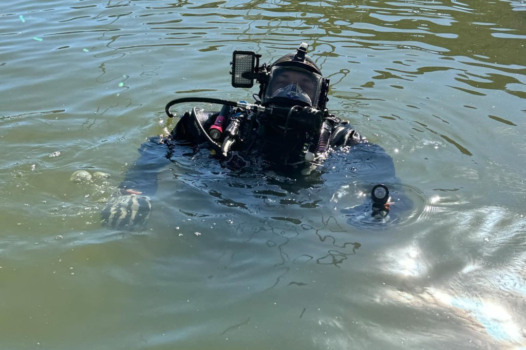 Diver in full scuba gear in the water.
