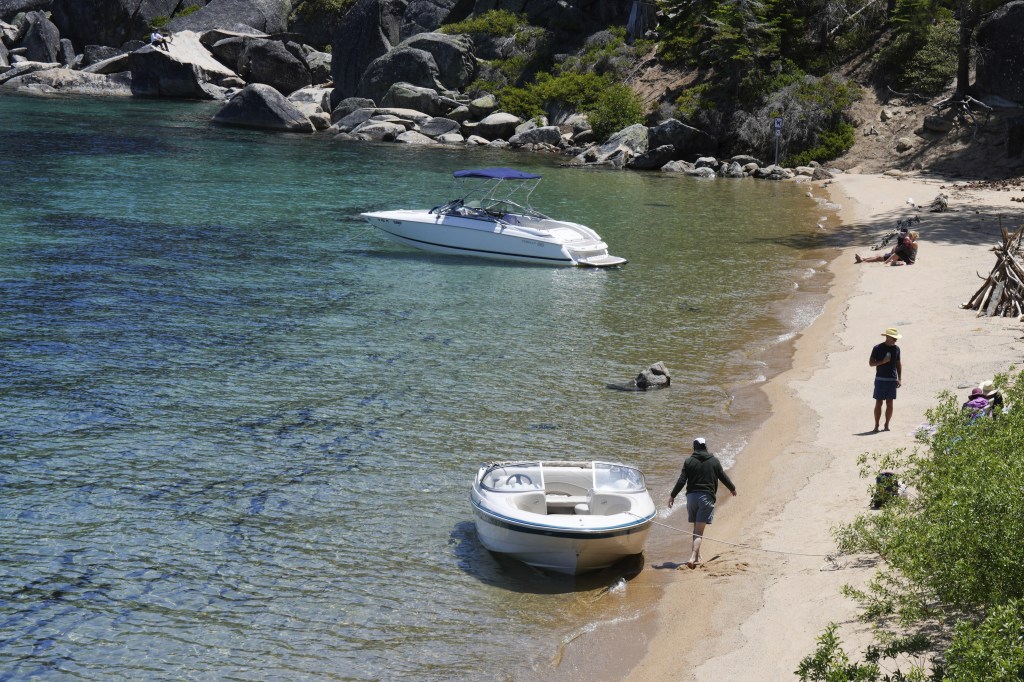 Two boats on a sandy beach at Lake Tahoe.