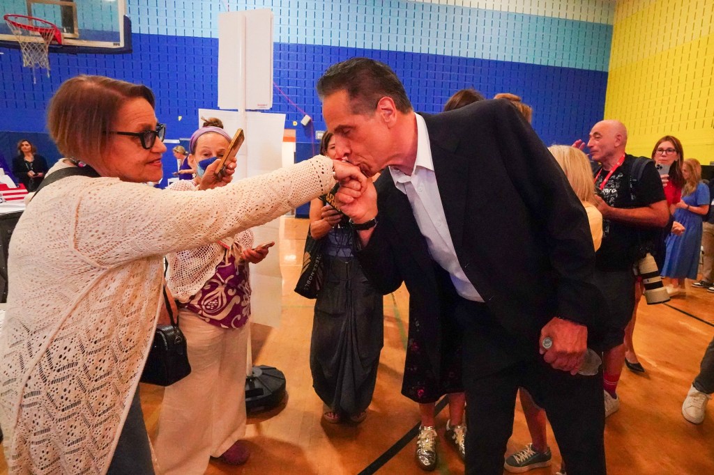 Cuomo kissing the hand of a woman at his polling place.