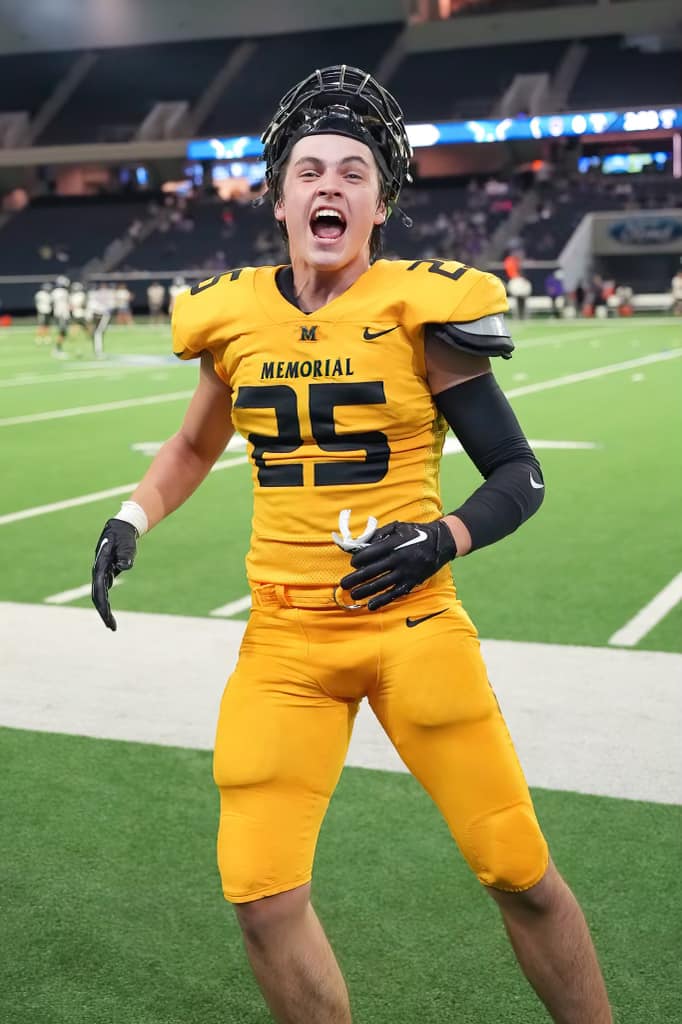 A football player in a yellow uniform celebrates on the field.