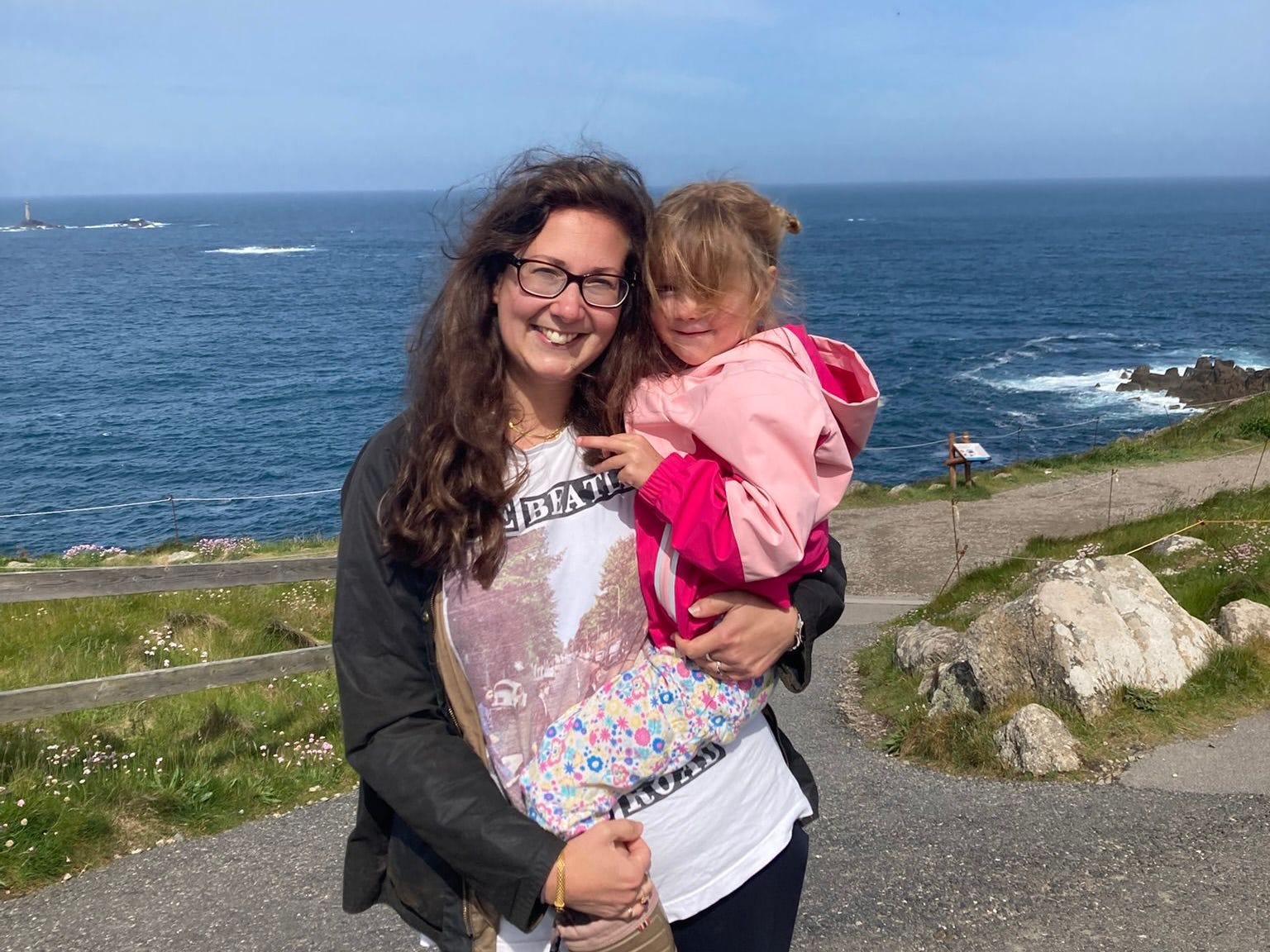The author with her daughter standing in front of the ocean.