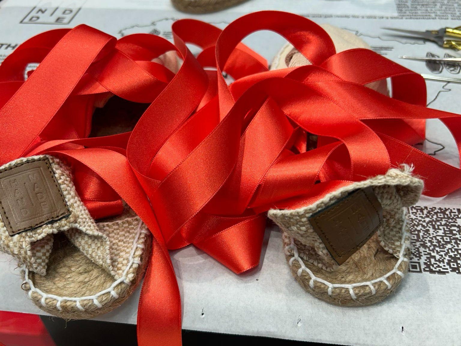 The author's view of her espadrilles as she was making them, complete with lots of red ribbon.