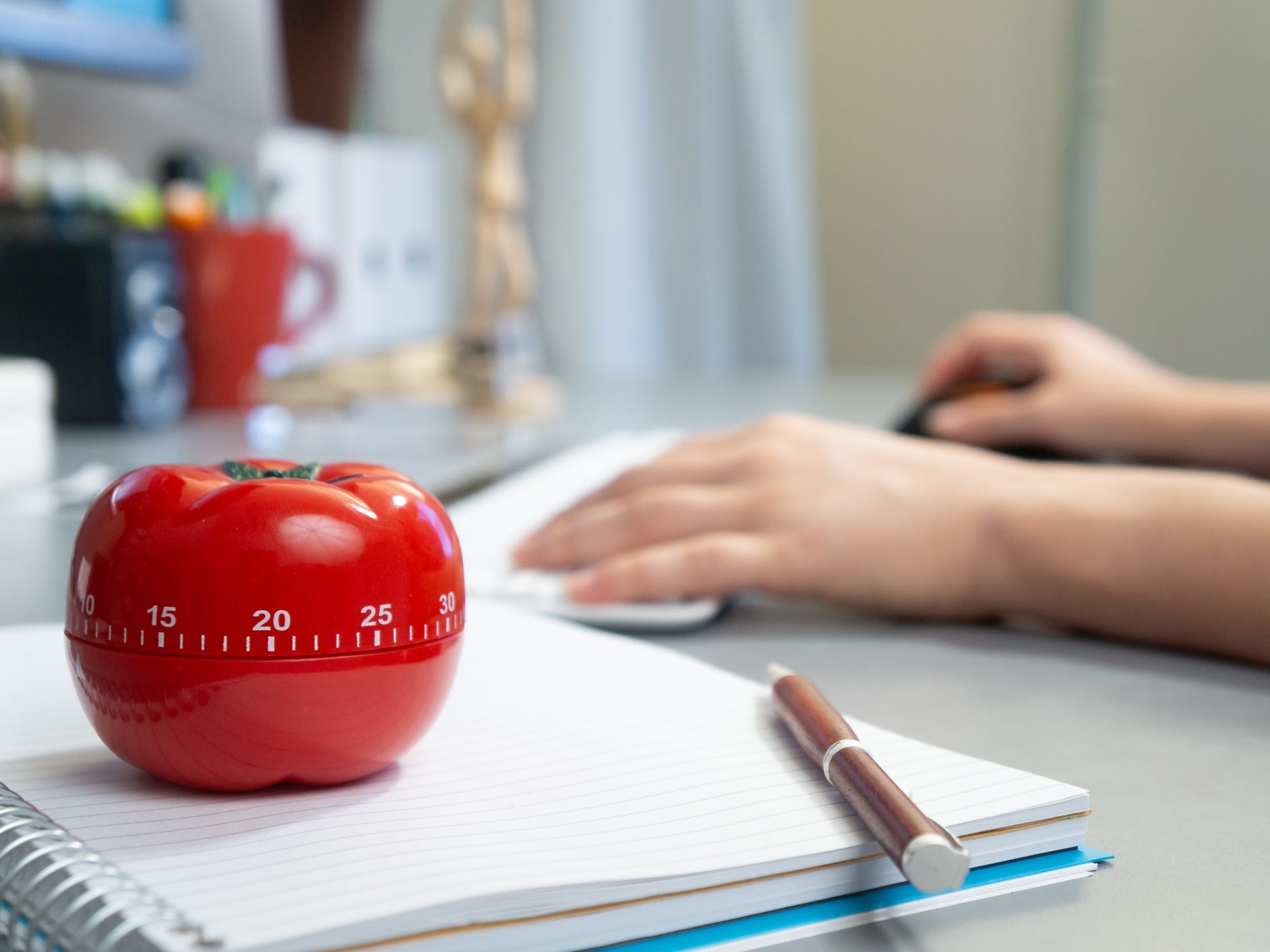 A person sitting at desk with tomato timer