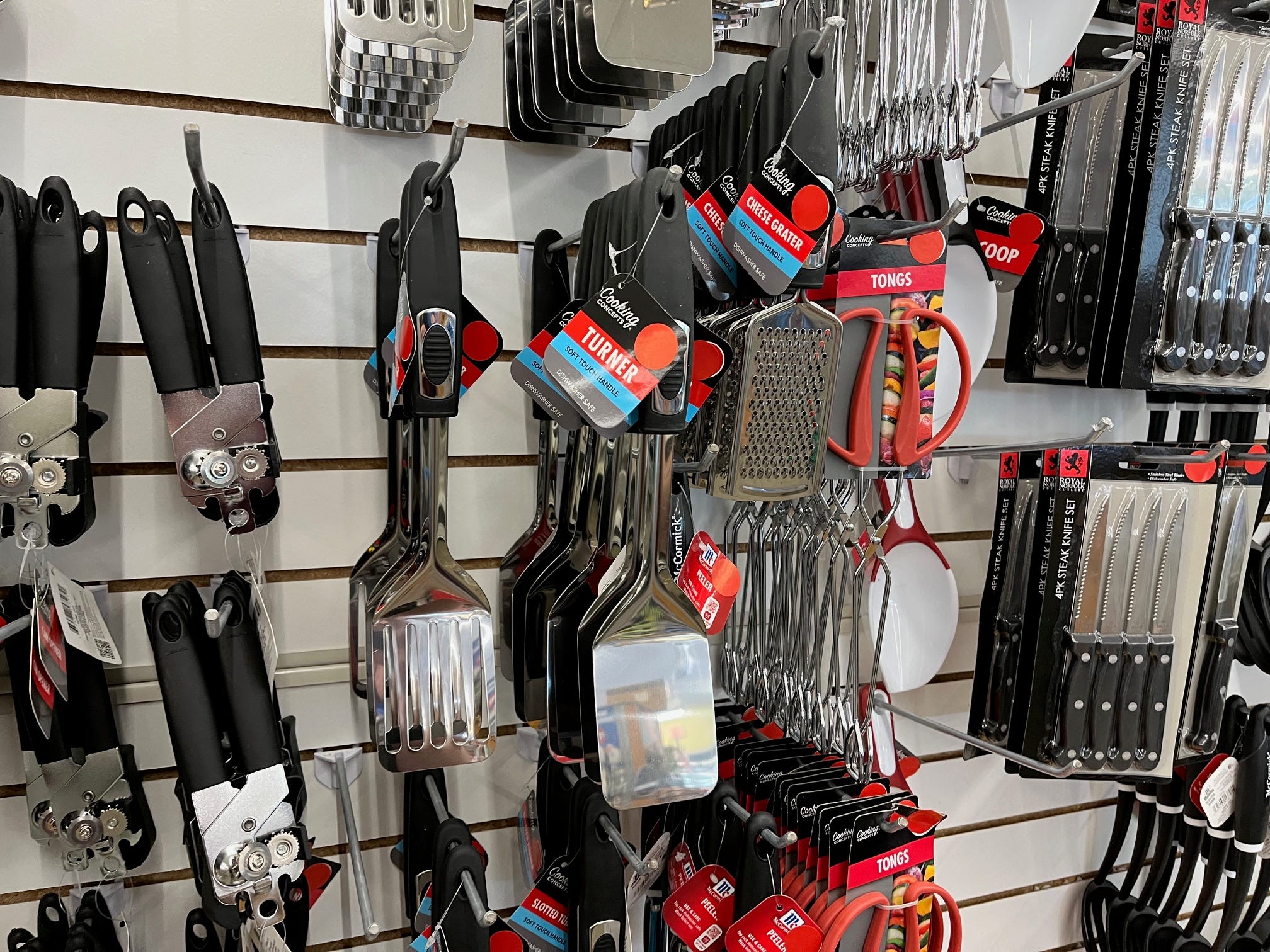 Red stickers cover the price of kitchen tools on tags at a Dollar Tree store.