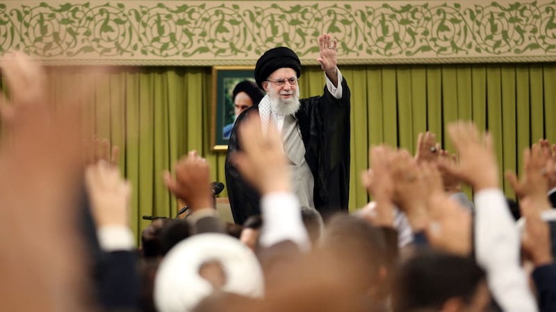 Ayatollah Ali Khamenei waves during a meeting with a group of teachers in Tehran on May 17, 2025.