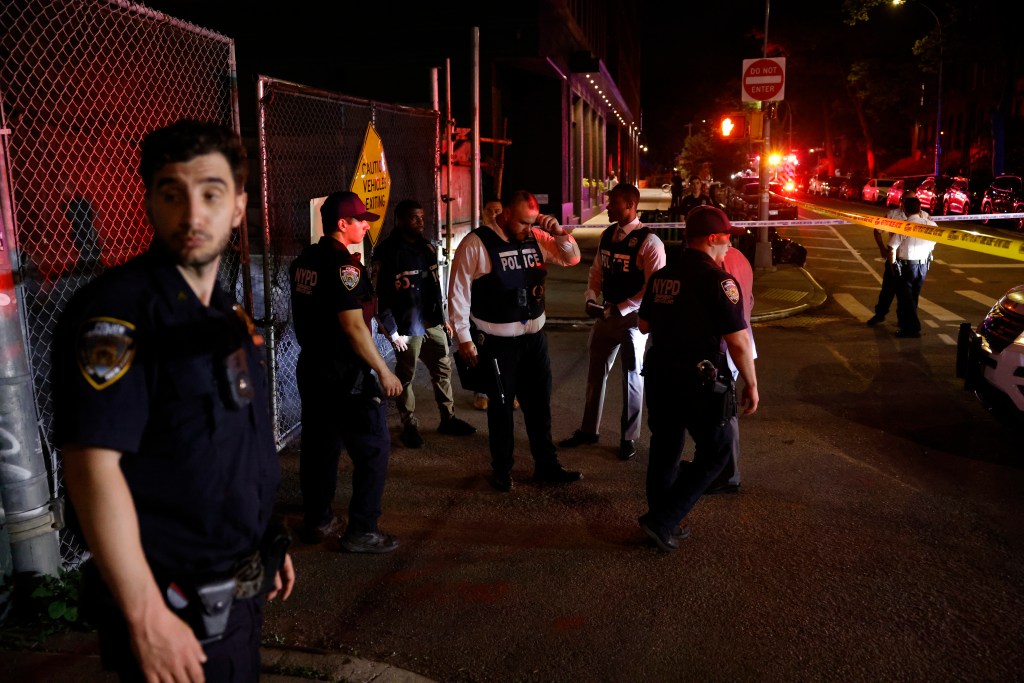 Police officers at a crime scene at night.