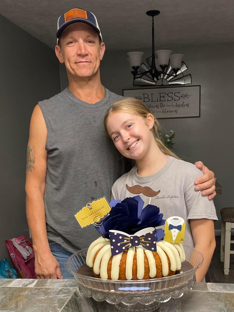 A father and daughter with a Father's Day cake.