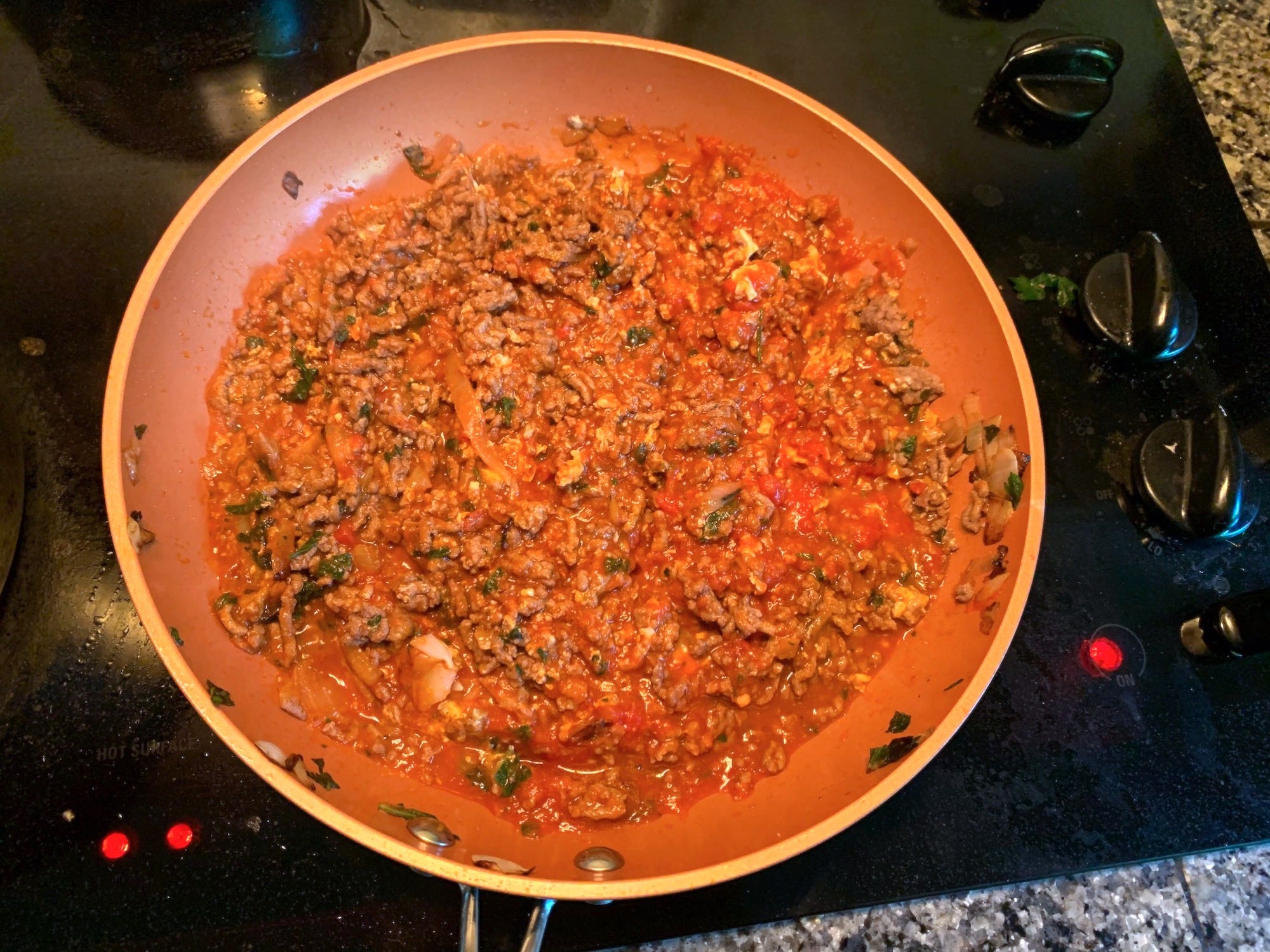 Ground beef mixed with marinara in a pan