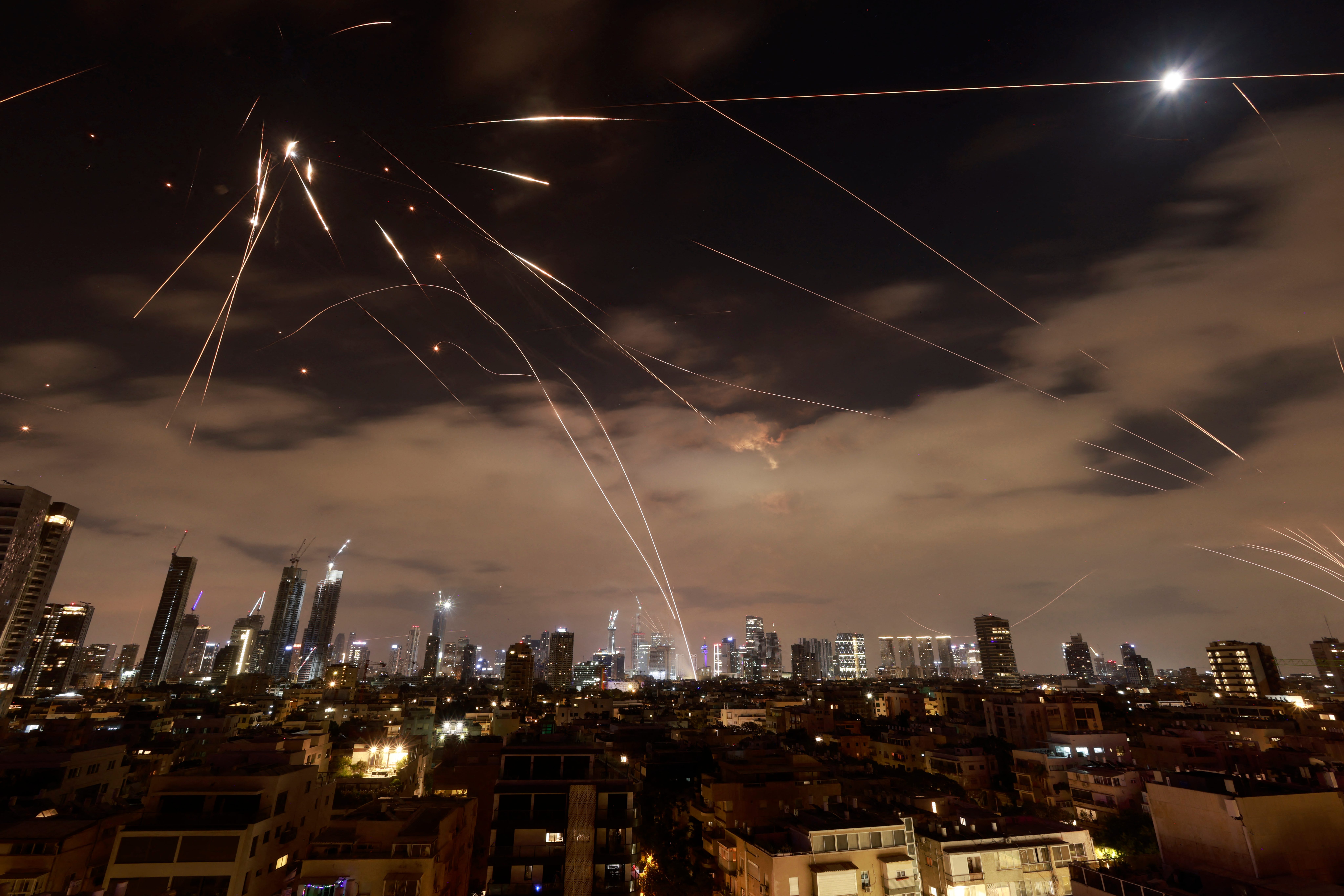 Israeli air defense systems intercept missiles over Tel Aviv.