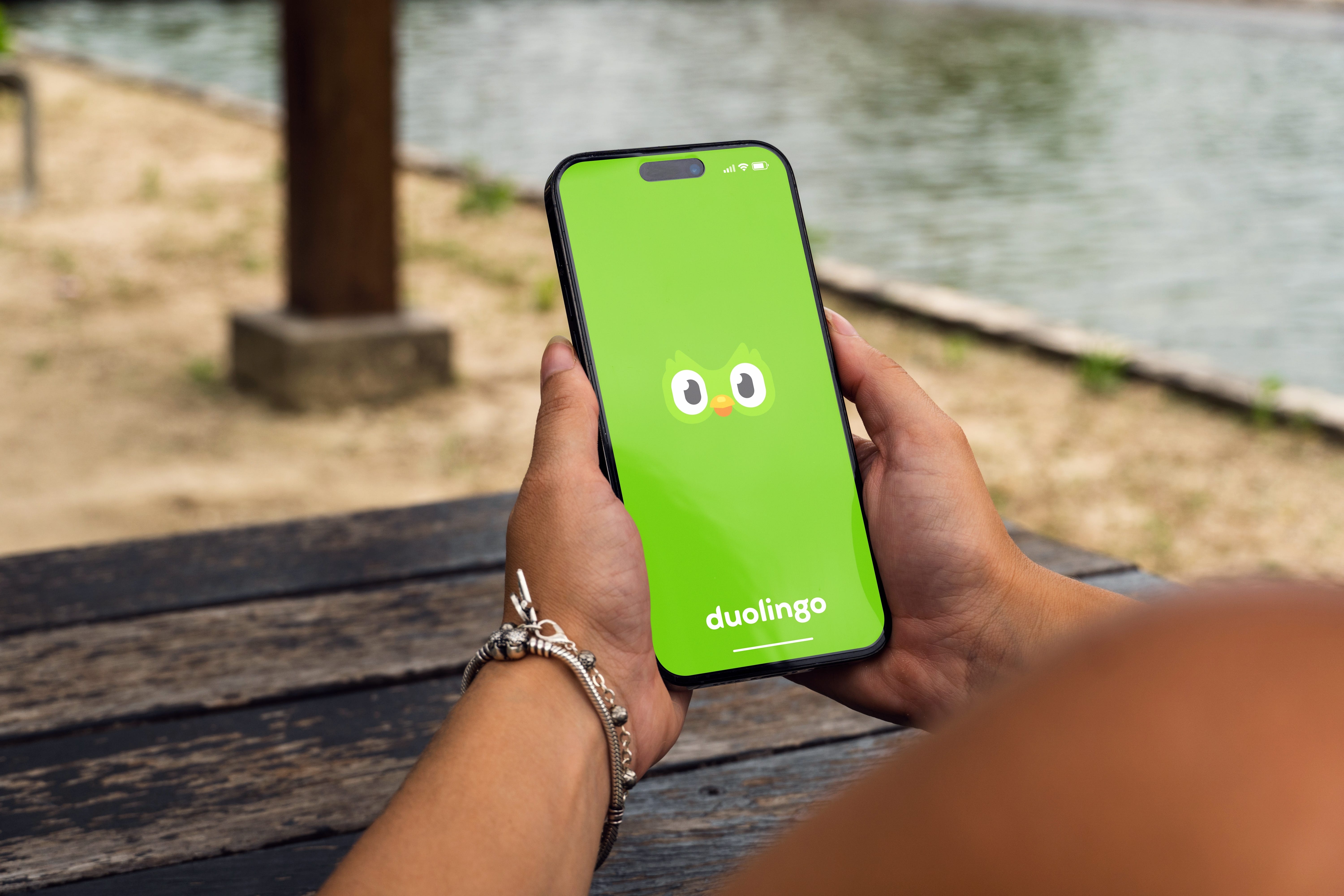 A woman opening Duolingo on her phone.