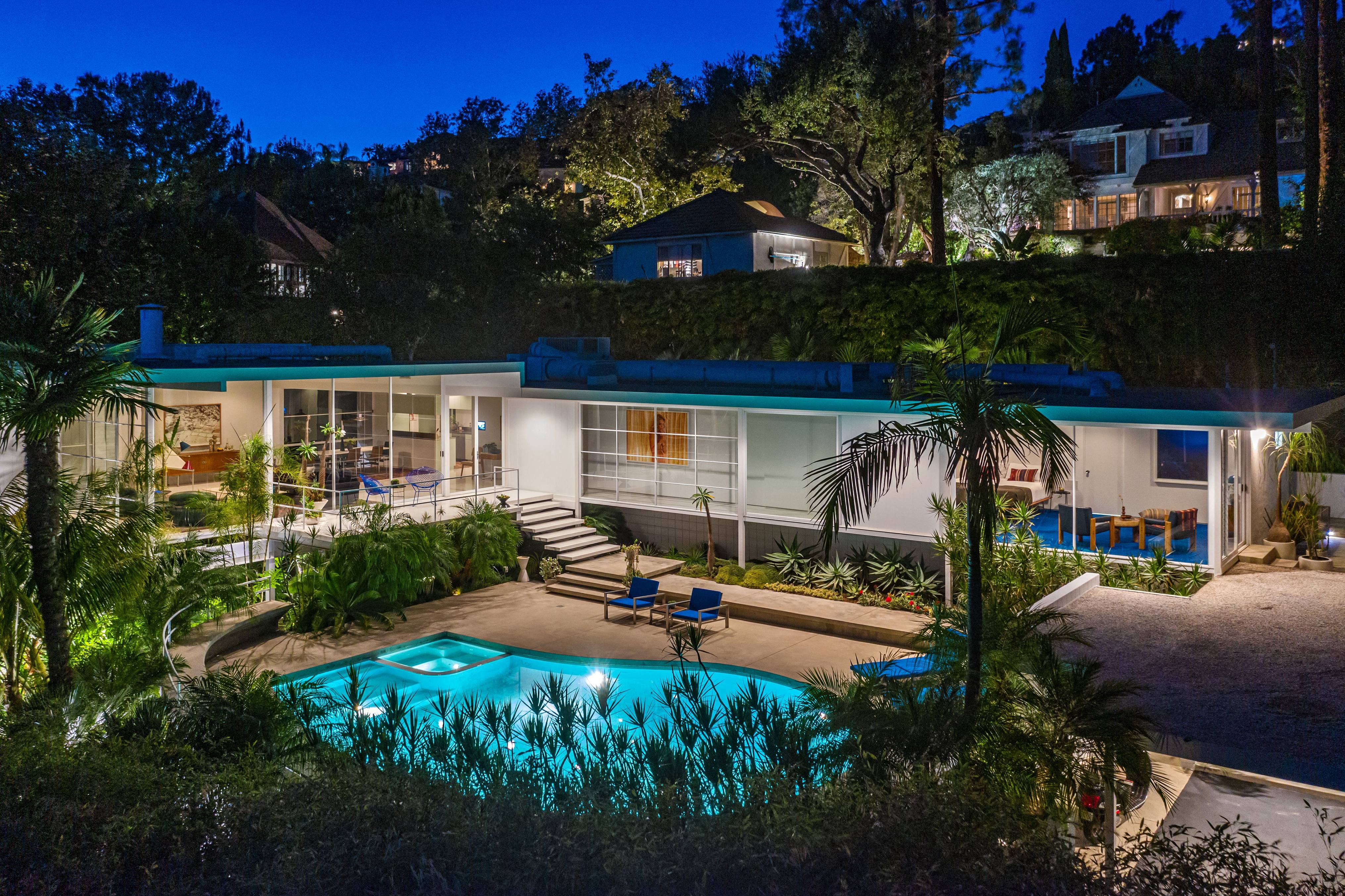 An image of a Los Angeles mansion and pool at night. 