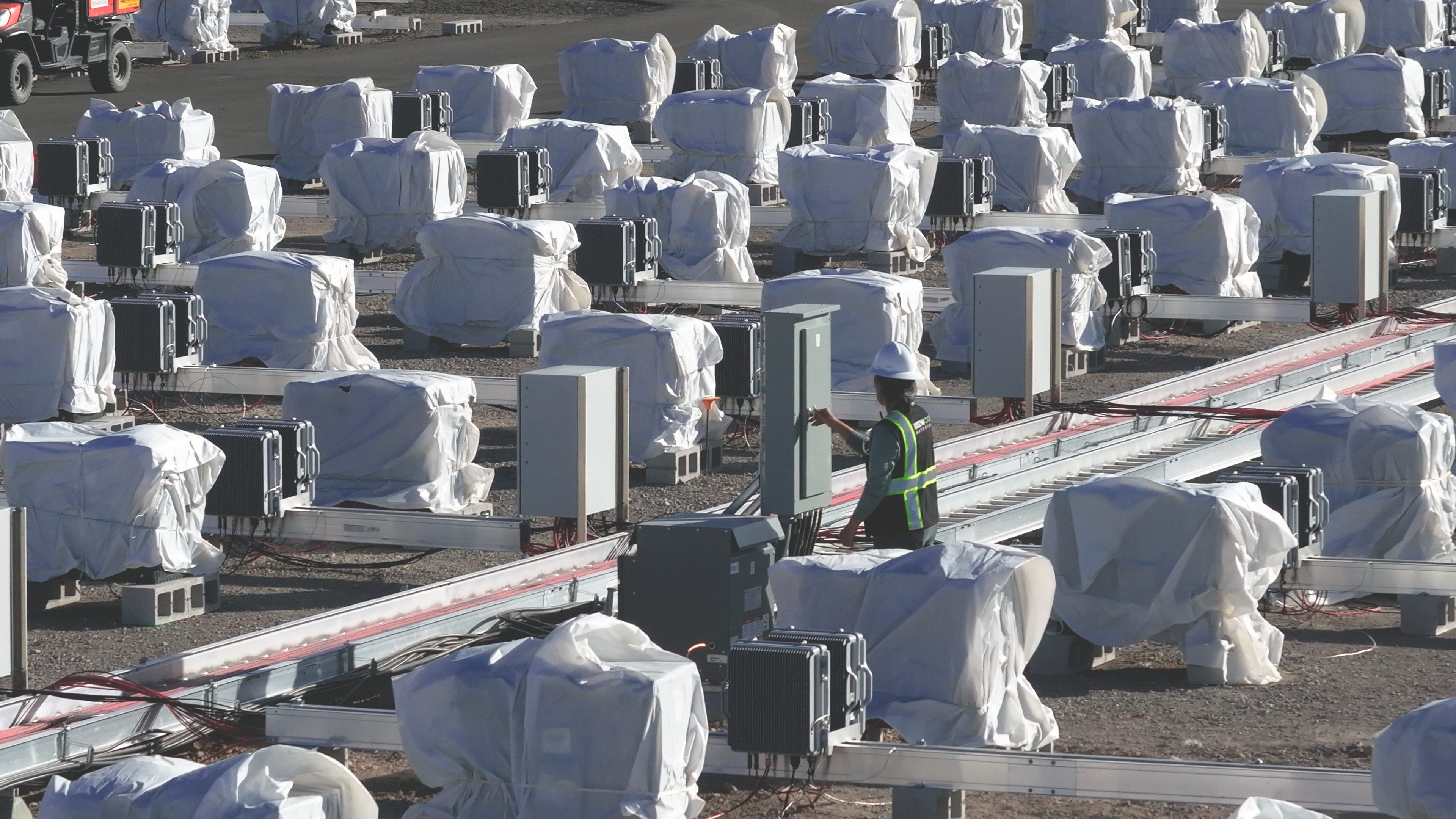 A Redwood Materials worker surrounded by battery packs that are part of the company's new energy storage system