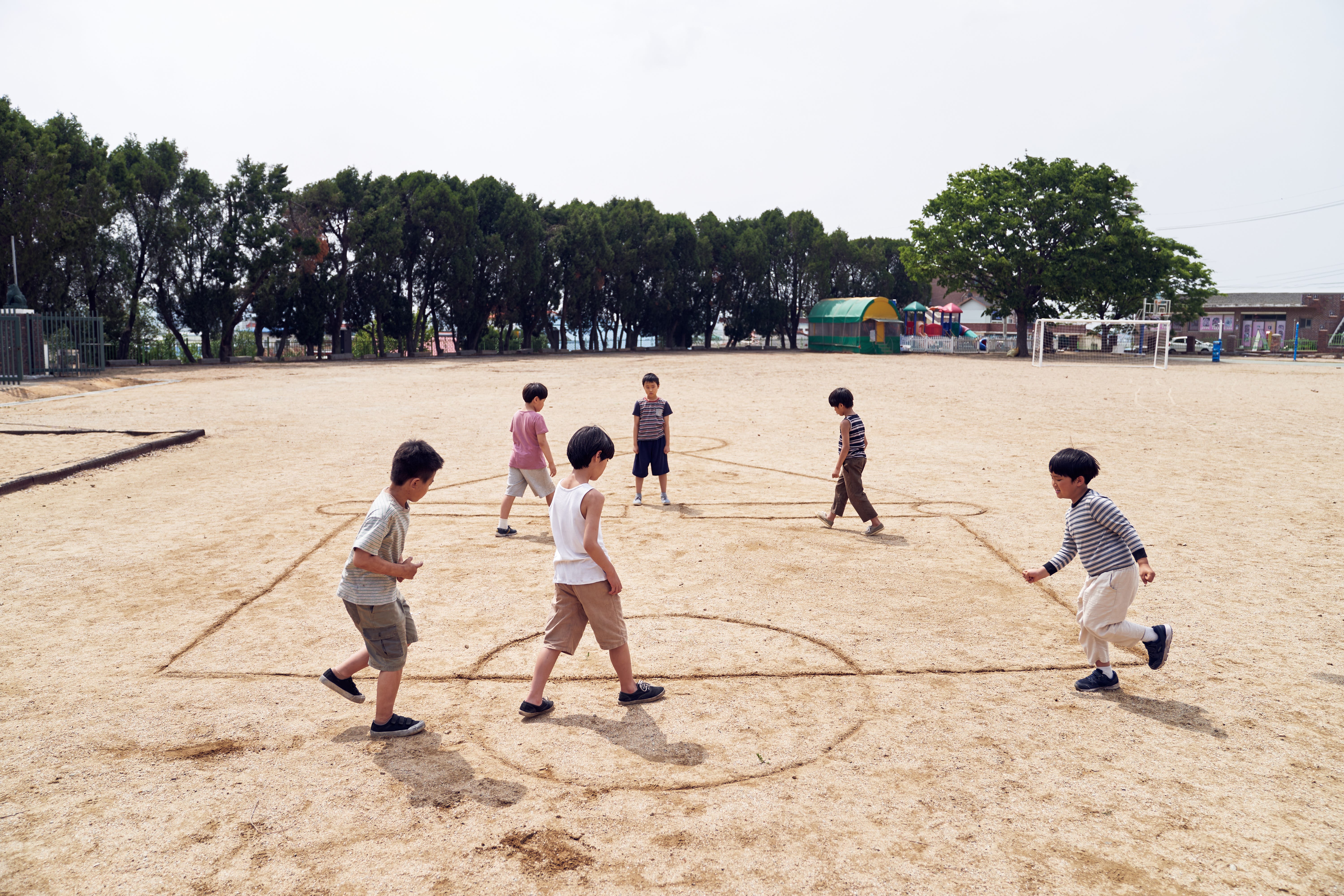 A still of "Squid Game" showing children playing in sand.