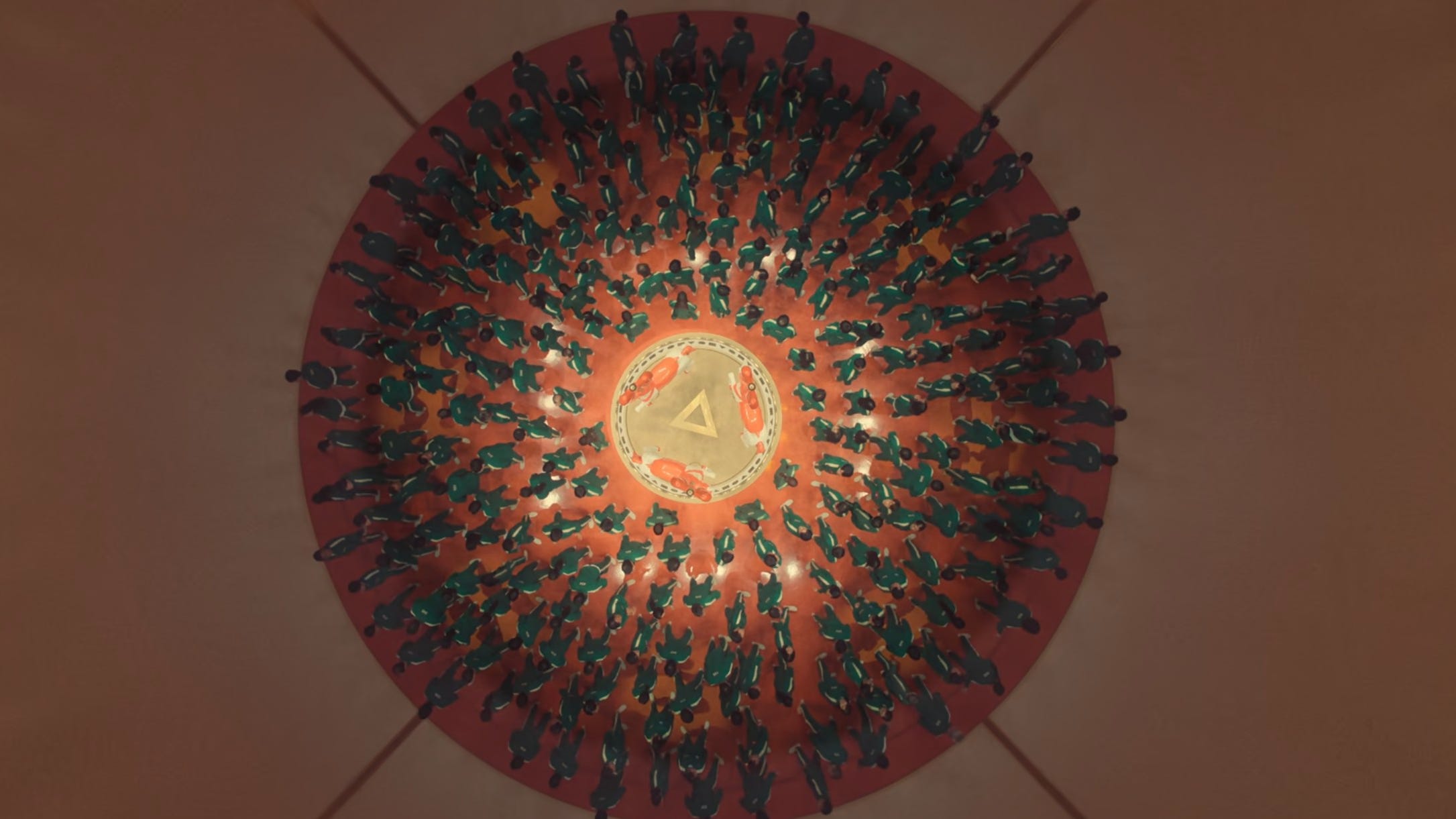 A still of "Squid Game" season two, episode five showing an aerial shot of a carousel filled with people on them.