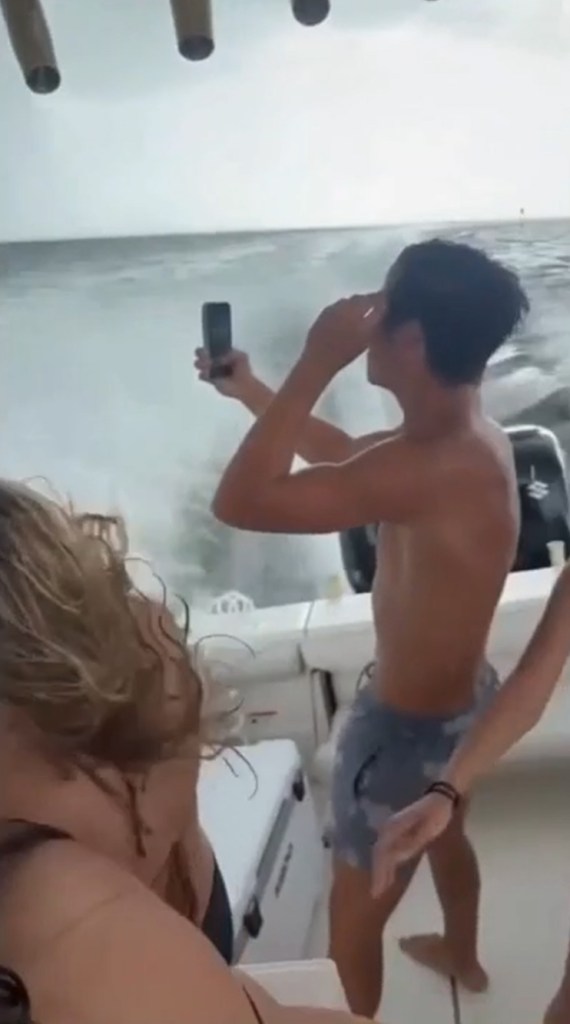 People on a boat filming dual waterspouts.