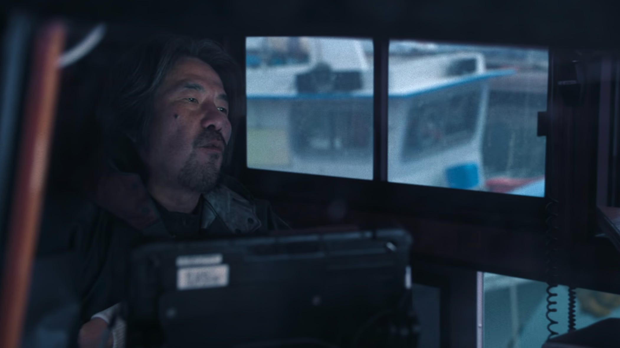 A screengrab of "Squid Game" season two, episode one showing a man in a boat control room.