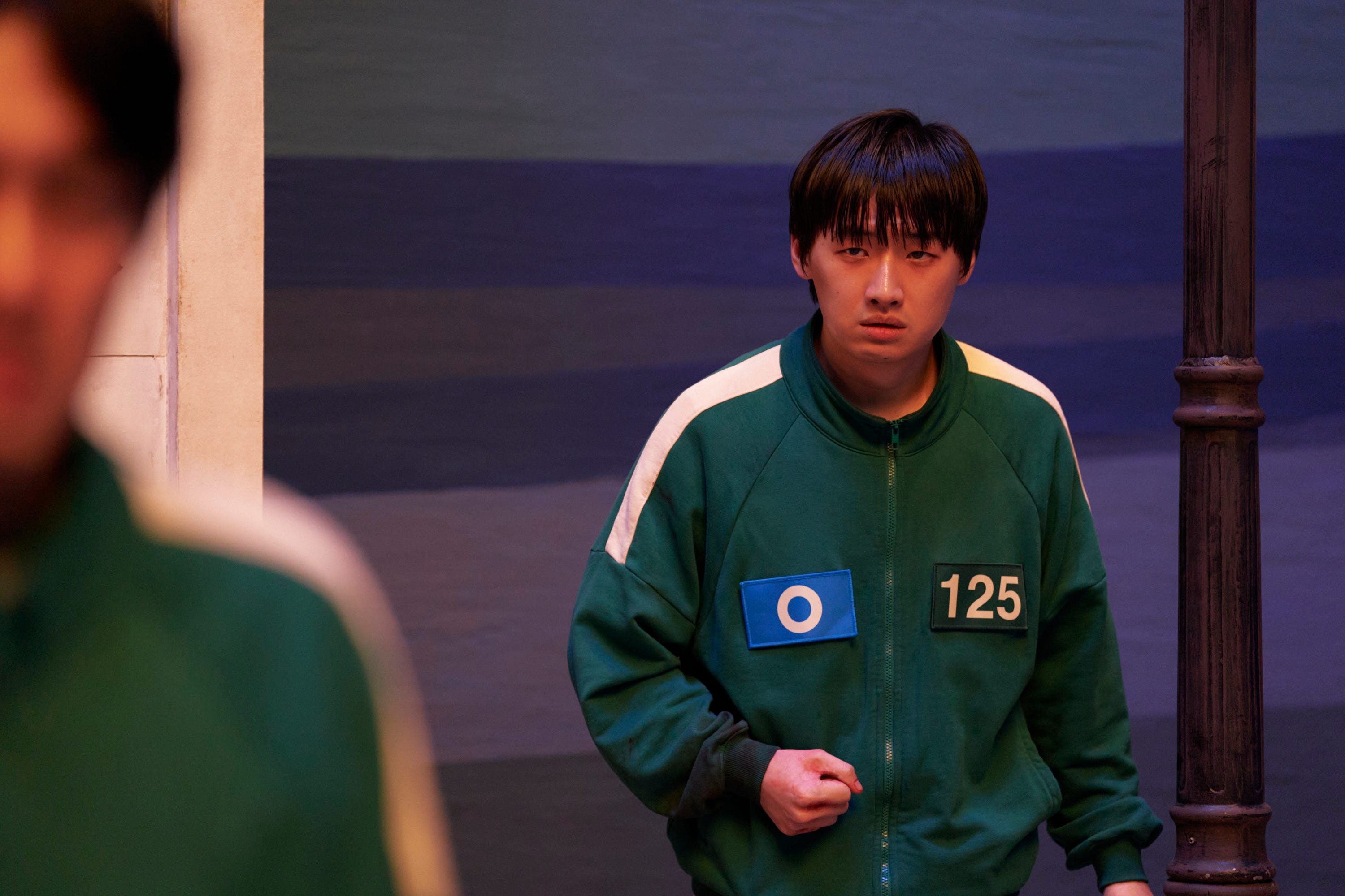 A still of "Squid Game" showing a man in a green tracksuit.