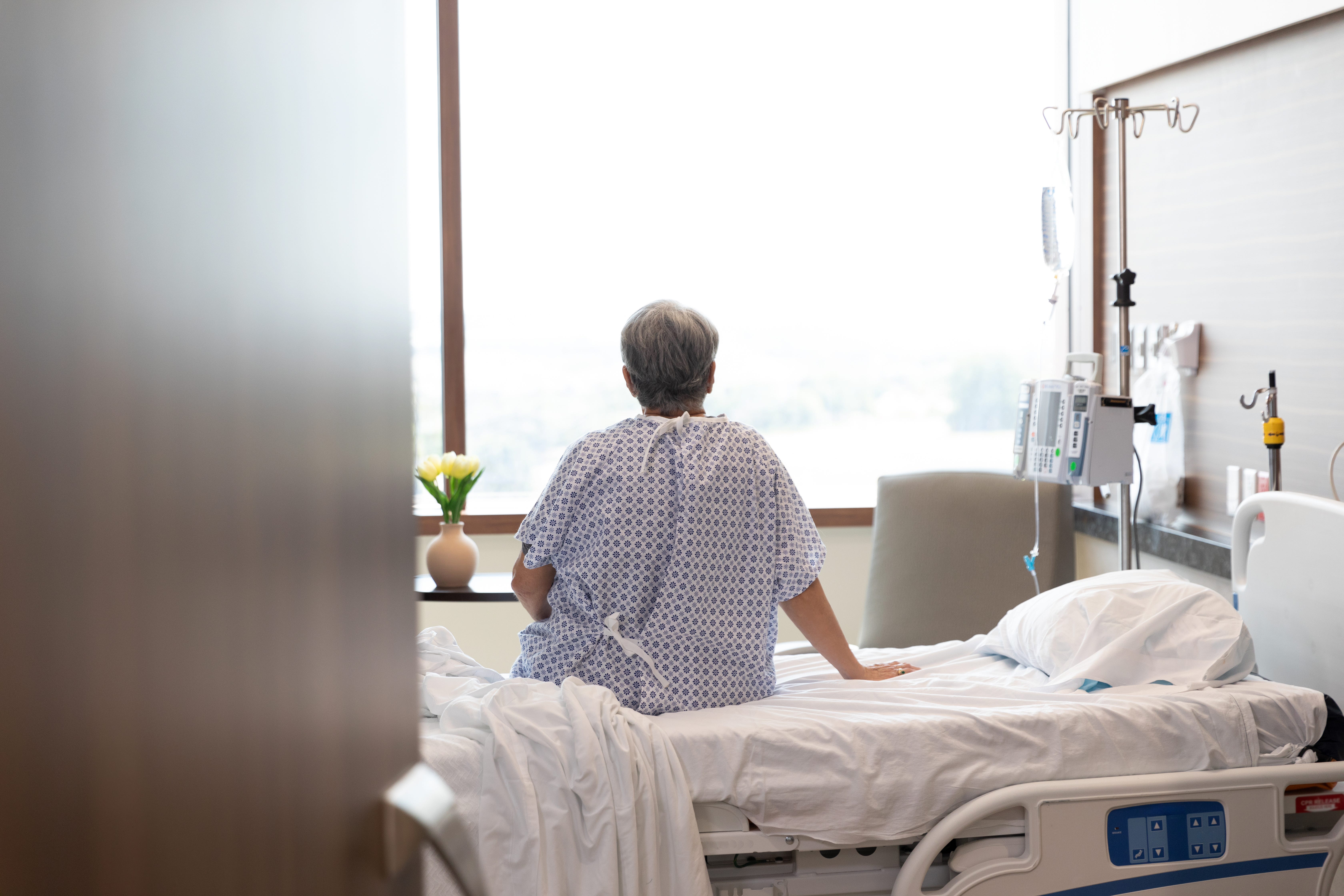 patient in a hospital bed looking out window