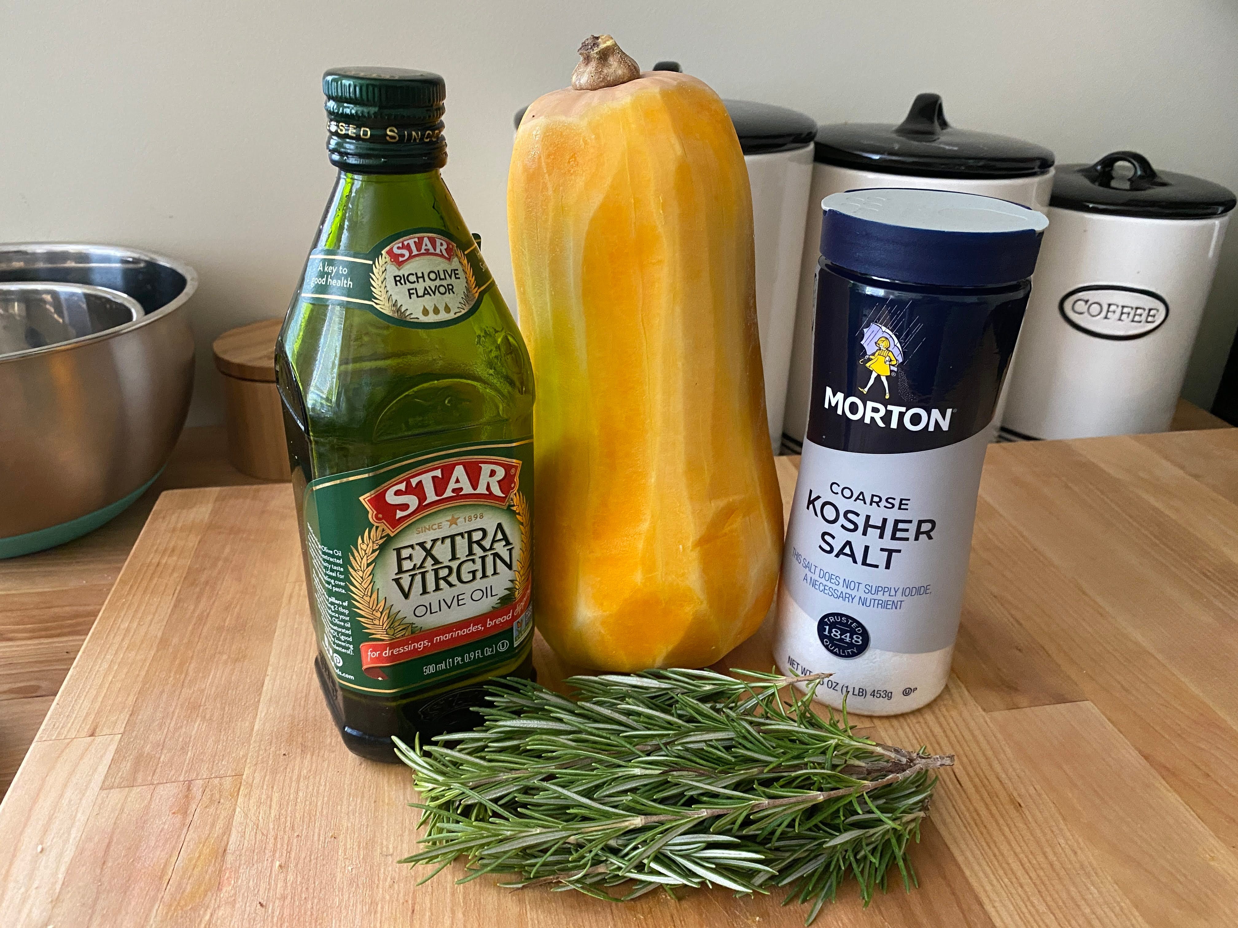 A photo of olive oil, butternut squash, kosher salt, and fresh rosemary