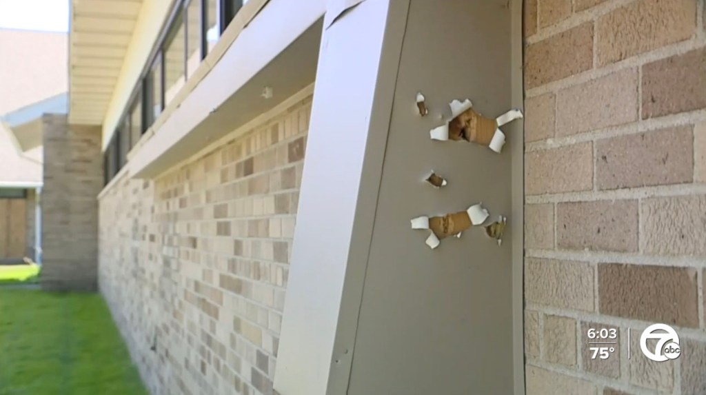 Bullet holes in a building's exterior wall.