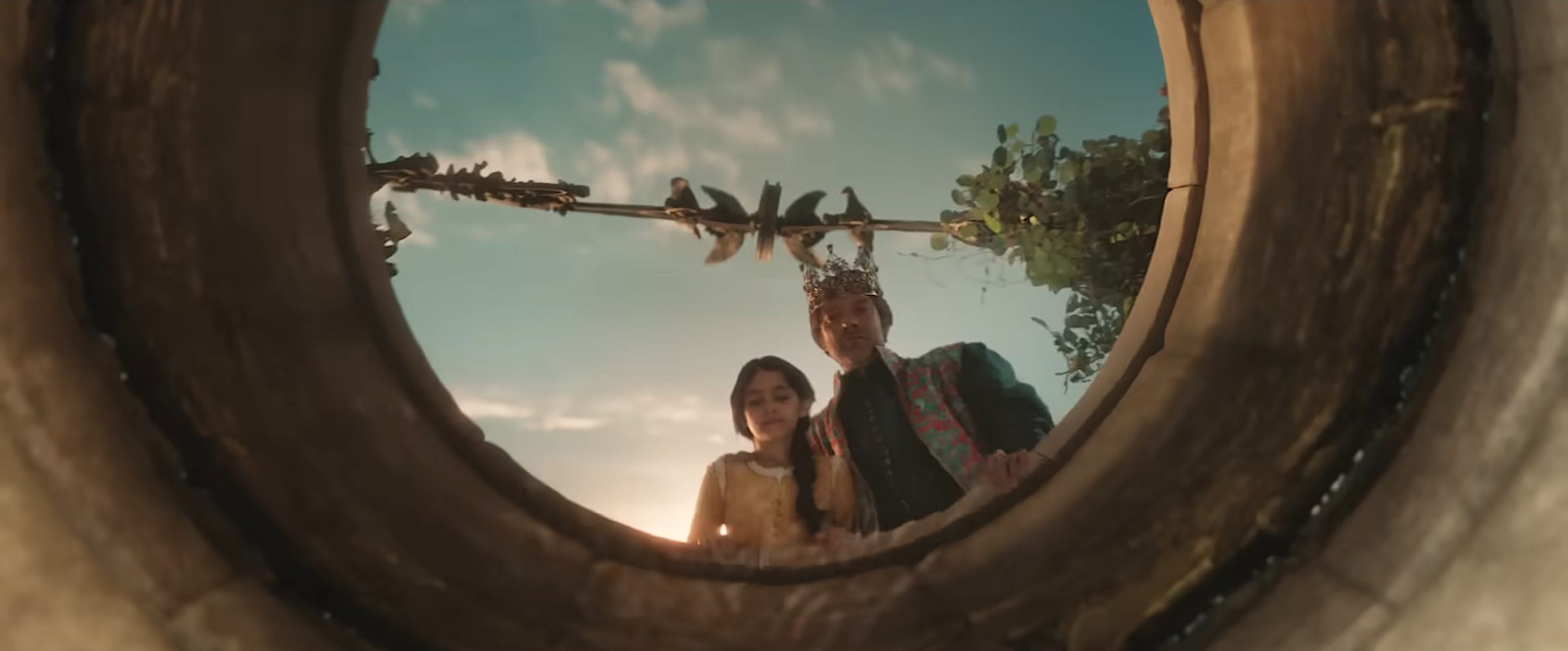 Young Snow White and the king peering into a well in "Snow White."