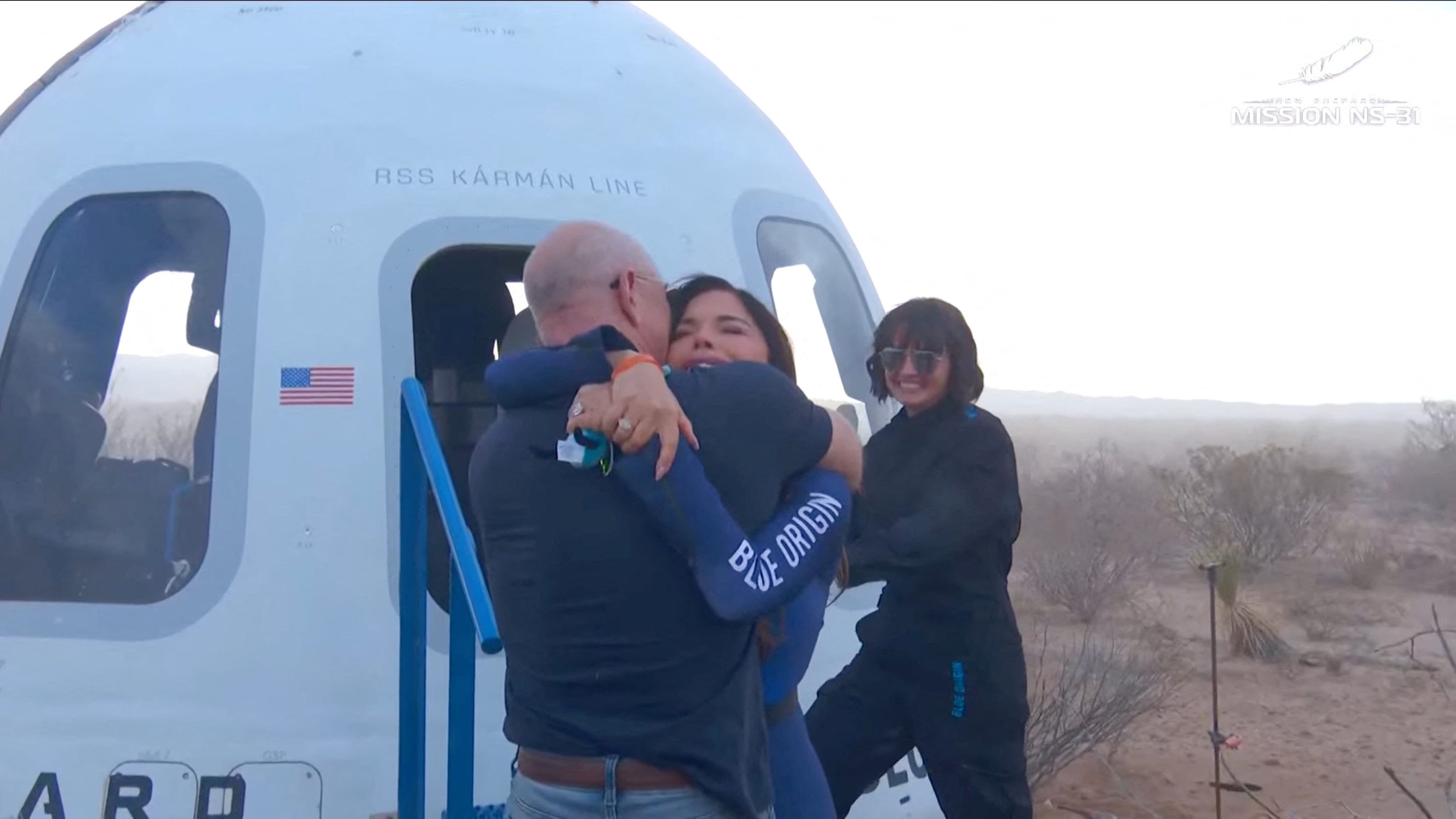 lauren sanchez hugs jeff bezos in front of blue origin new shepard space vehicle