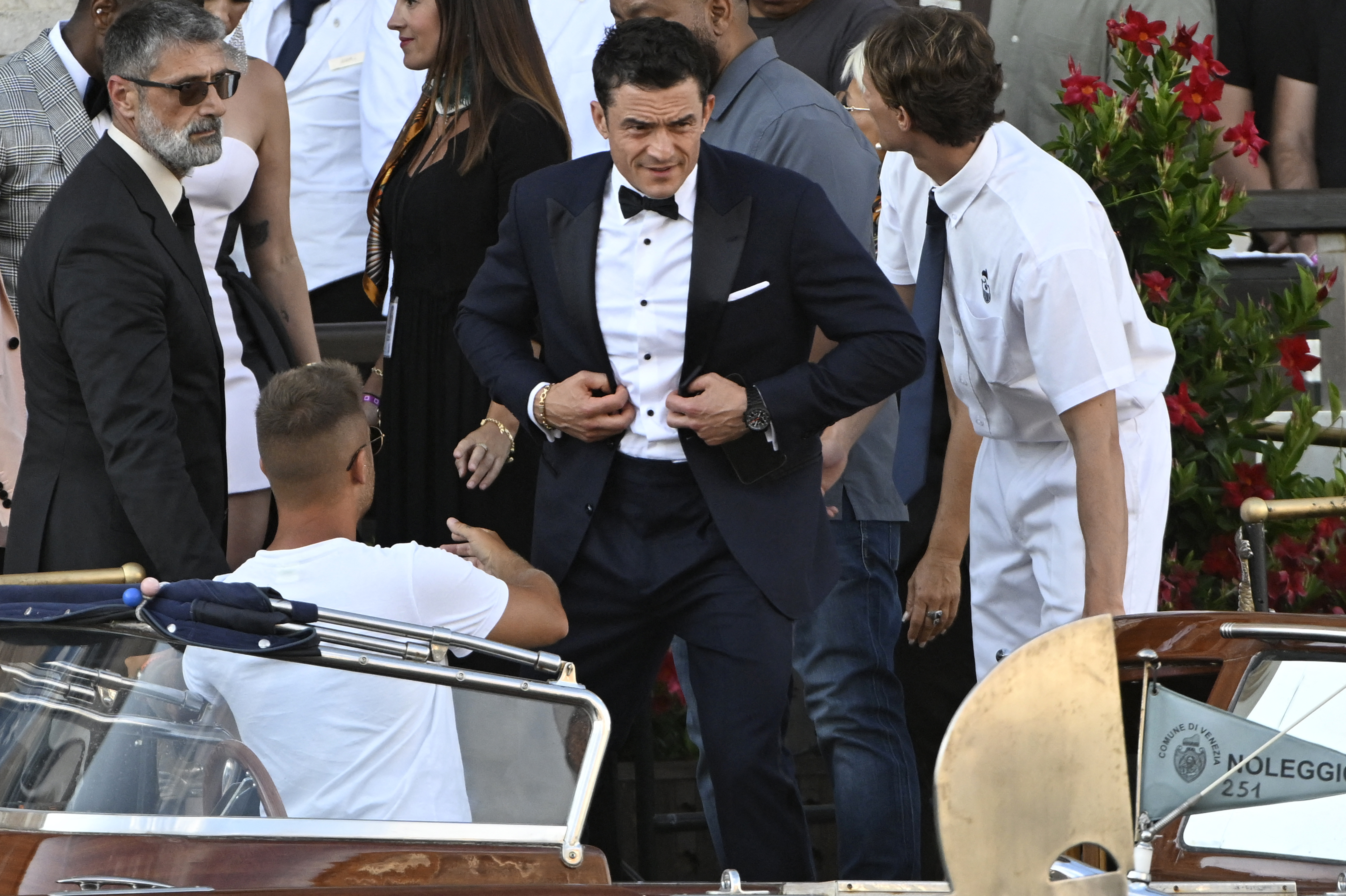 Orlando Bloom buttons his tuxedo. 